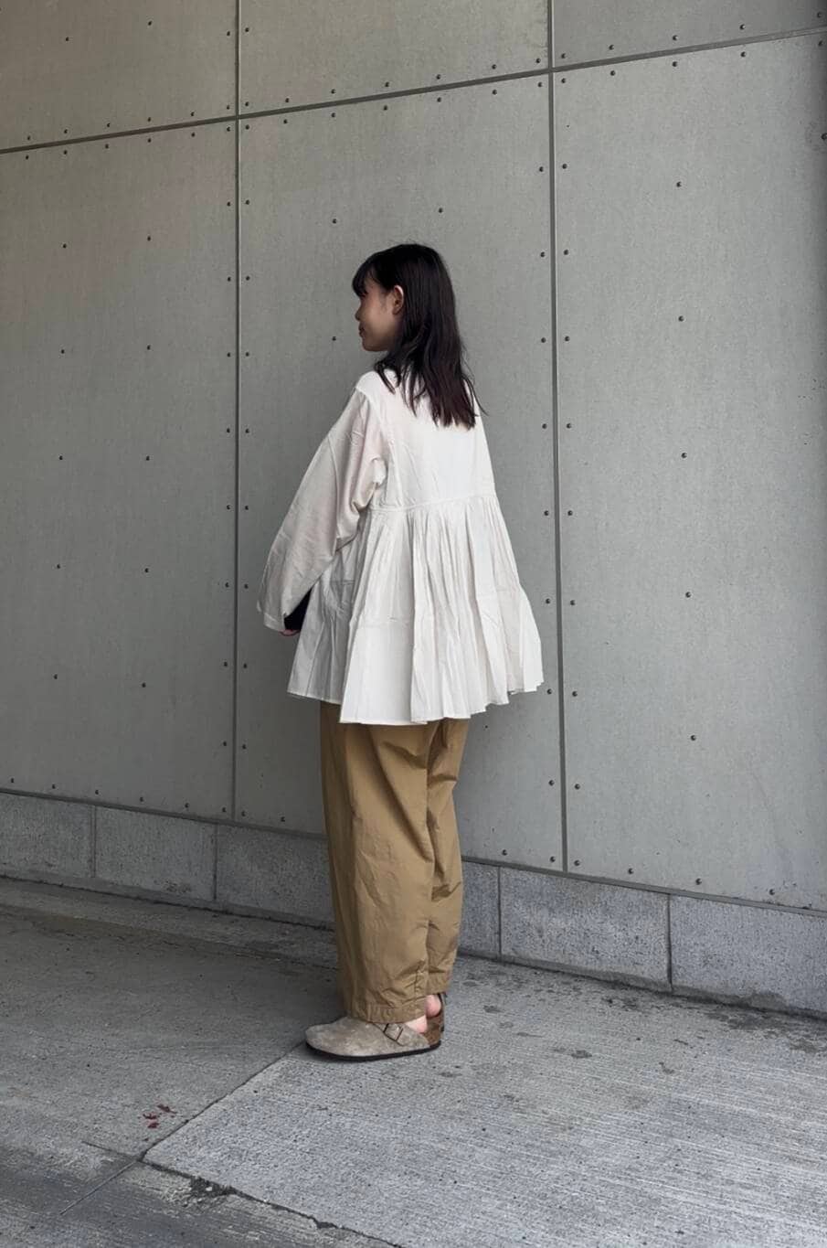 ベージュ系のその他パンツ、ブラック系のハンドバッグ、グレー系のシャツ/ブラウスを着用したレディースの夏コーディネートの3枚目の写真