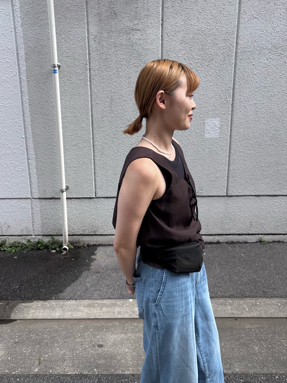ブルー系のデニムパンツ、ブラック系のサンダル、グレー系のその他トップスを着用したレディースの夏コーディネートの3枚目の写真