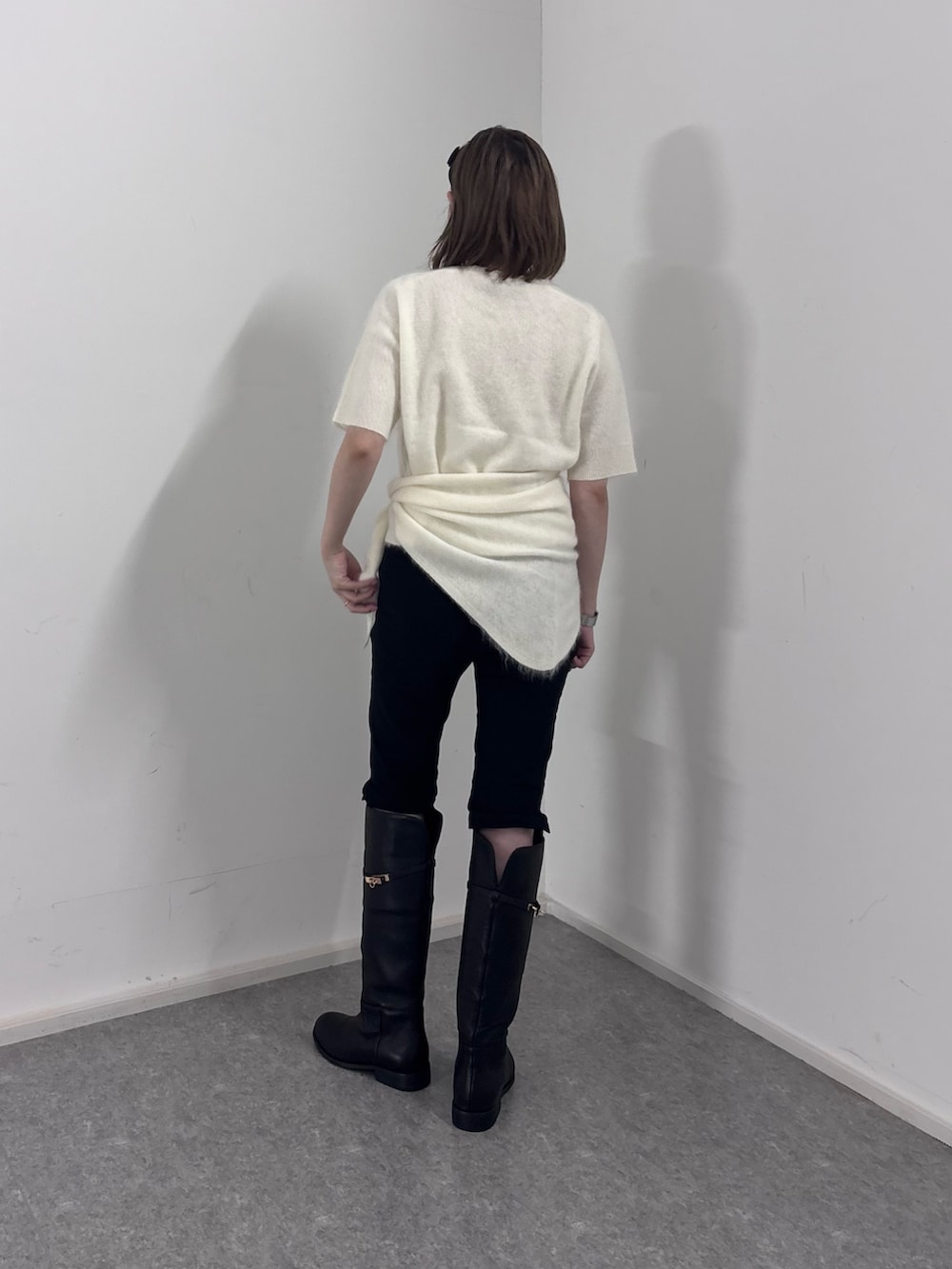 ホワイト系のニット/セーター、ブラック系のその他パンツ、ブラック系のブーツを着用したレディースの秋コーディネートの3枚目の写真