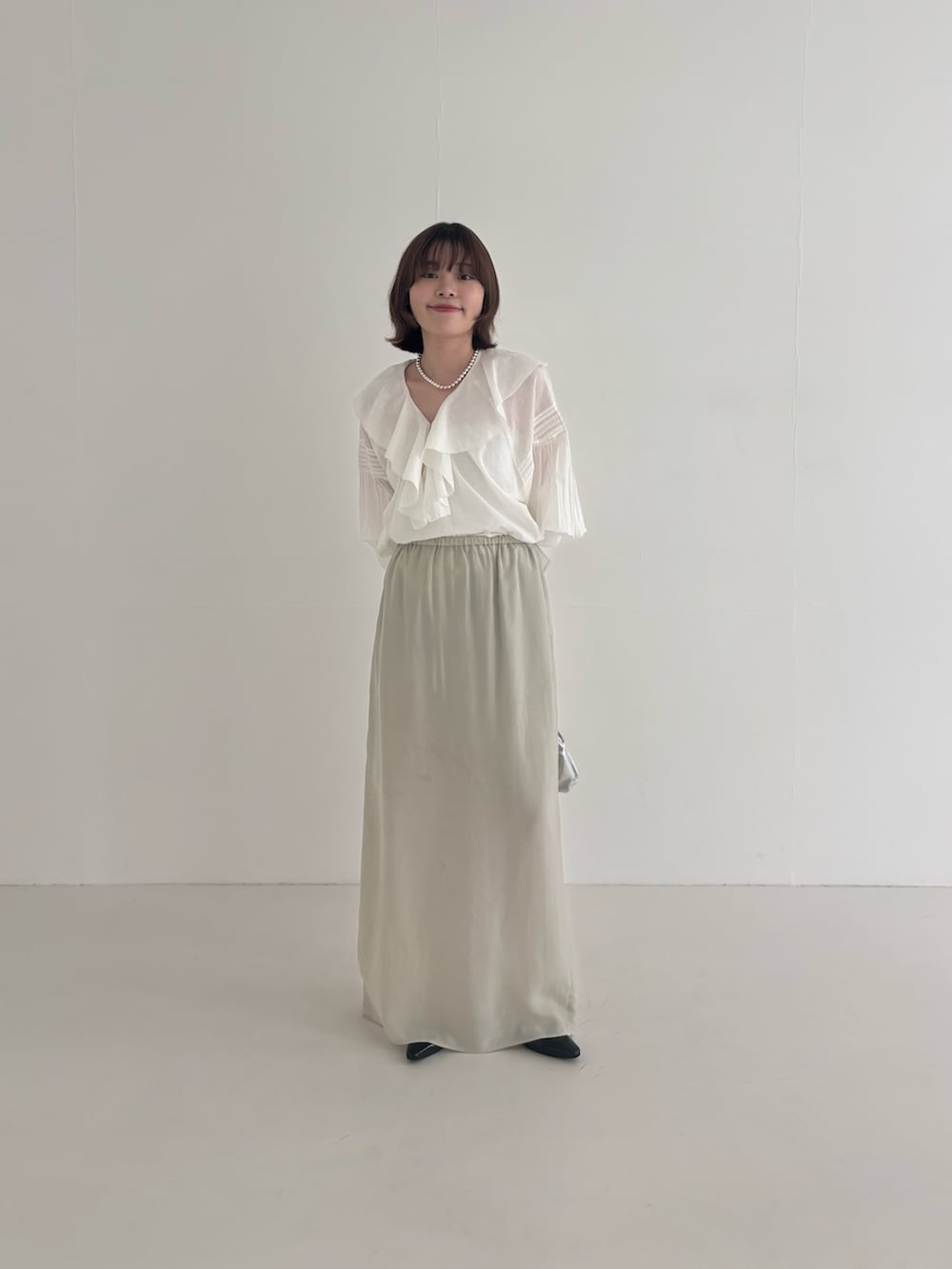 ブルー系のその他アウター、ベージュ系のスカート、ブラック系のパンプスを着用したレディースの春コーディネートの5枚目の写真