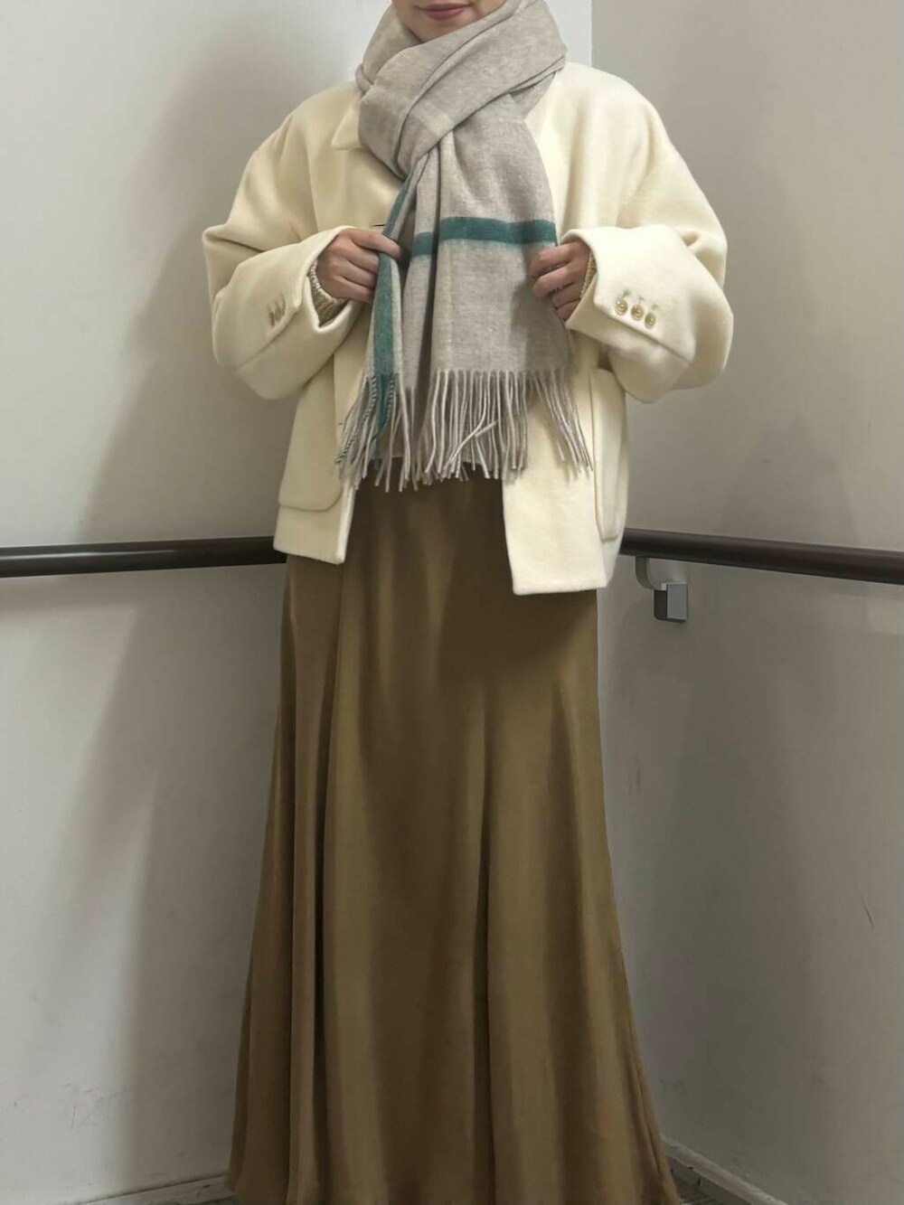 ホワイト系のその他アウター、イエロー系のスカート、ホワイト系のカーディガン/ボレロを着用したレディースの冬コーディネートの3枚目の写真