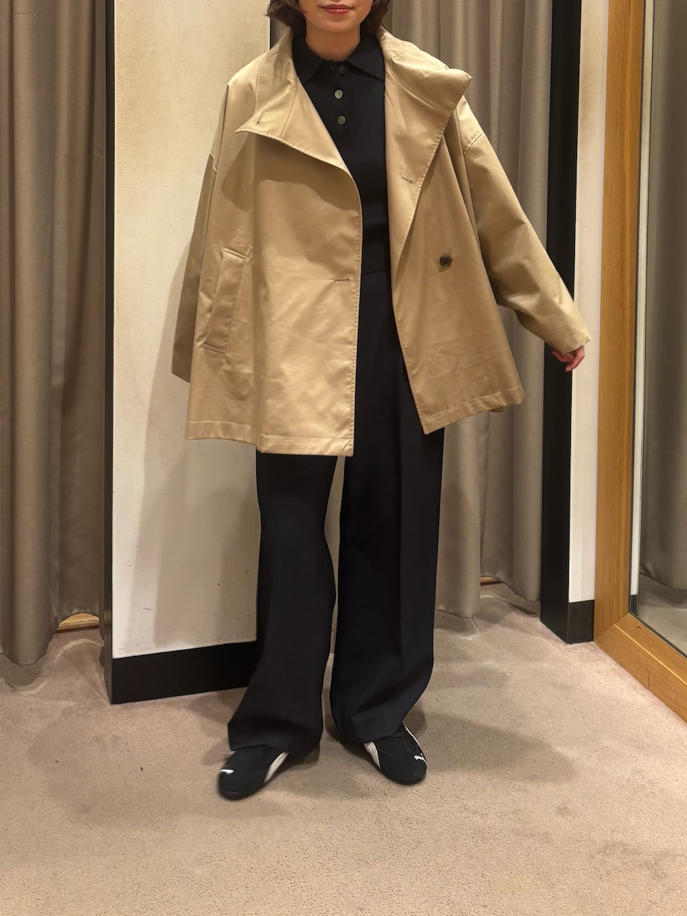 ベージュ系のトレンチコート、ブルー系のその他パンツ、ブラック系のスニーカーを着用したレディースの冬コーディネートの3枚目の写真