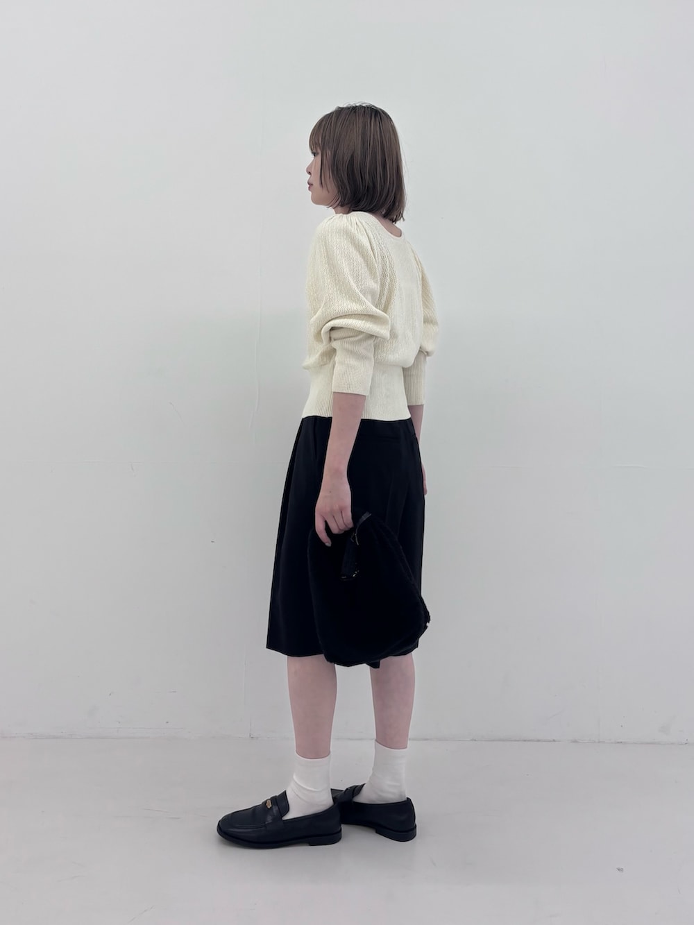 ホワイト系のニット/セーター、ブラック系のその他パンツ、ホワイト系のネックレスを着用したレディースの秋コーディネートの4枚目の写真
