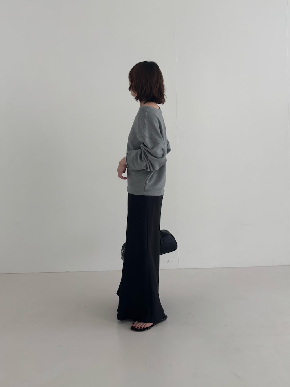 ブラック系のスカート、グレー系のスウェット、ブラック系のショルダーバッグを着用したレディースの春コーディネートの4枚目の写真
