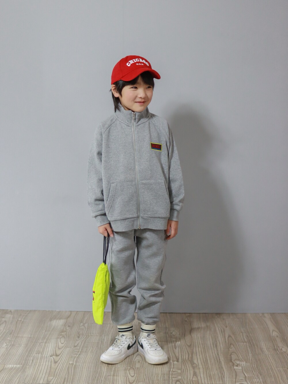 グレー系のスウェット、ホワイト系のスニーカー、イエロー系のランチョンマット/テーブルウェアを着用したキッズの冬コーディネートの2枚目の写真