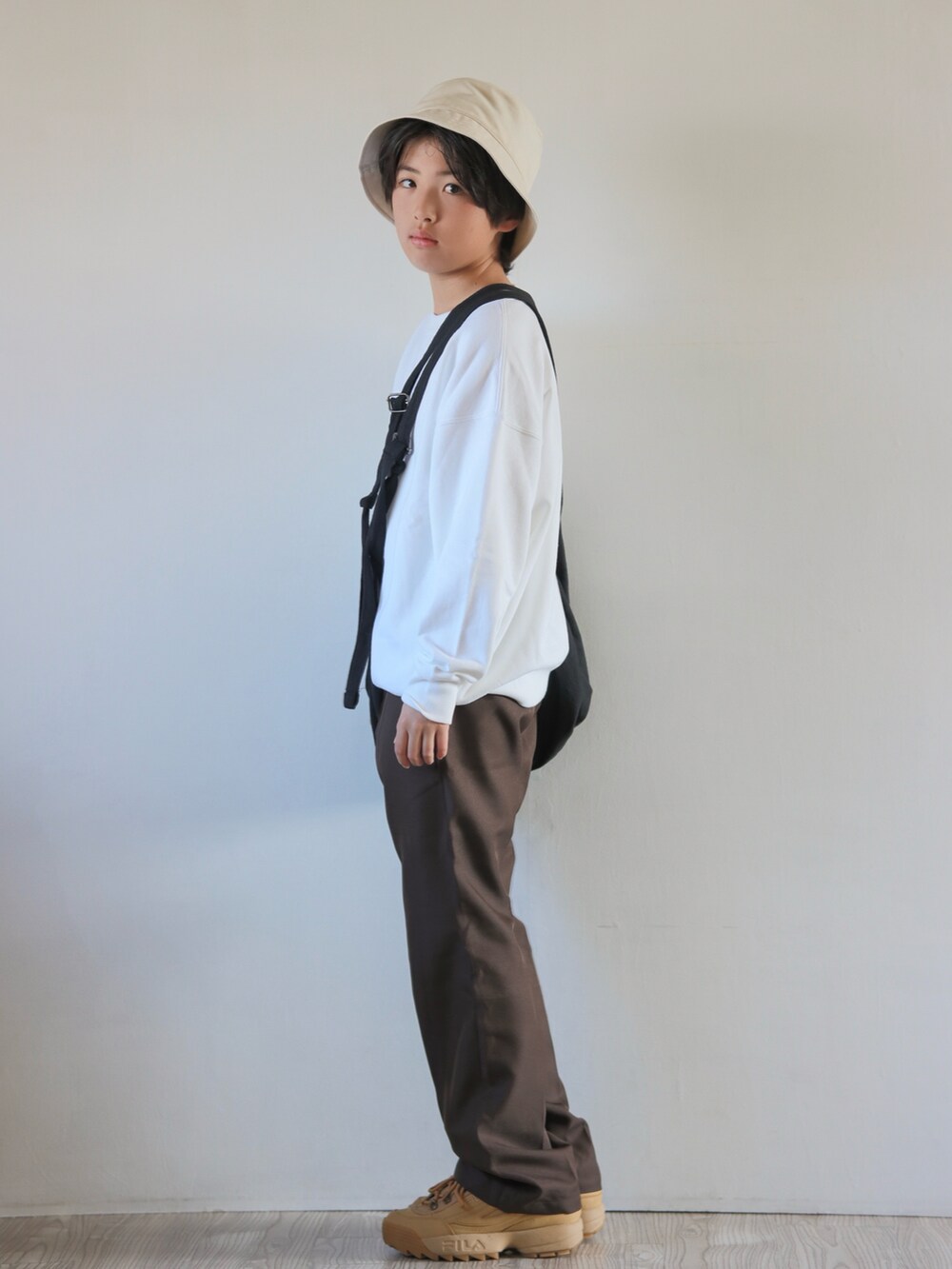ブラウン系のその他パンツ、ブラウン系のスニーカーを着用したキッズの冬コーディネートの2枚目の写真
