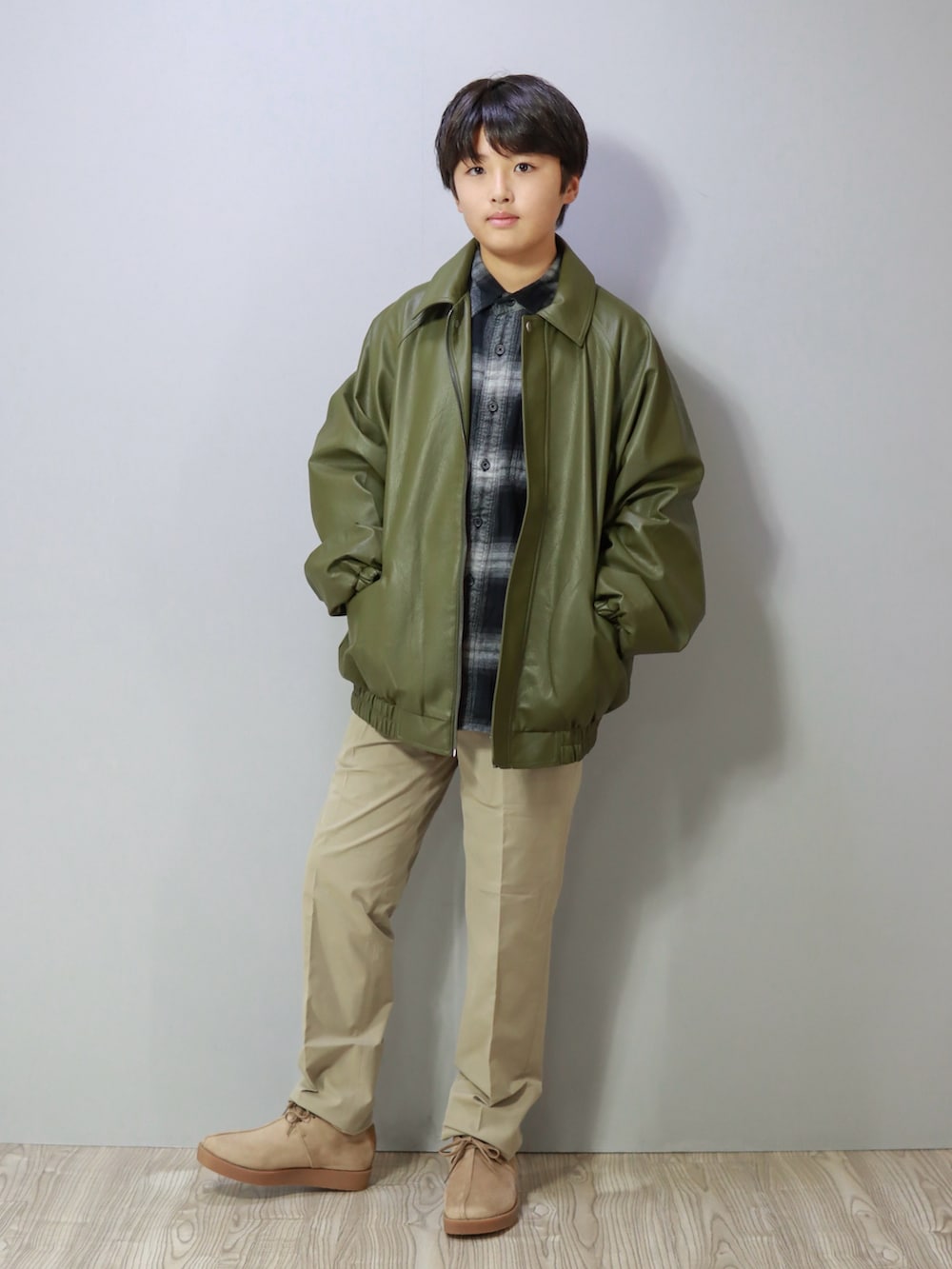 グリーン系のブルゾン、ベージュ系のモカシン/デッキシューズを着用したキッズの冬コーディネートの2枚目の写真