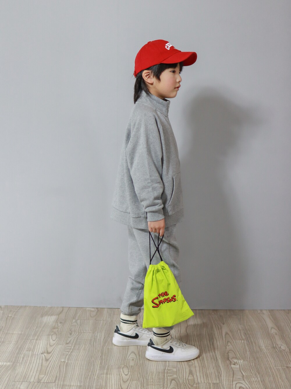 グレー系のスウェット、ホワイト系のスニーカー、イエロー系のランチョンマット/テーブルウェアを着用したキッズの冬コーディネートの3枚目の写真