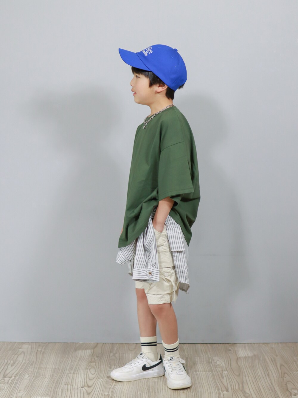 グリーン系のTシャツ/カットソー、グレー系のシャツ/ブラウス、ホワイト系のカーゴパンツを着用したキッズの春コーディネートの4枚目の写真