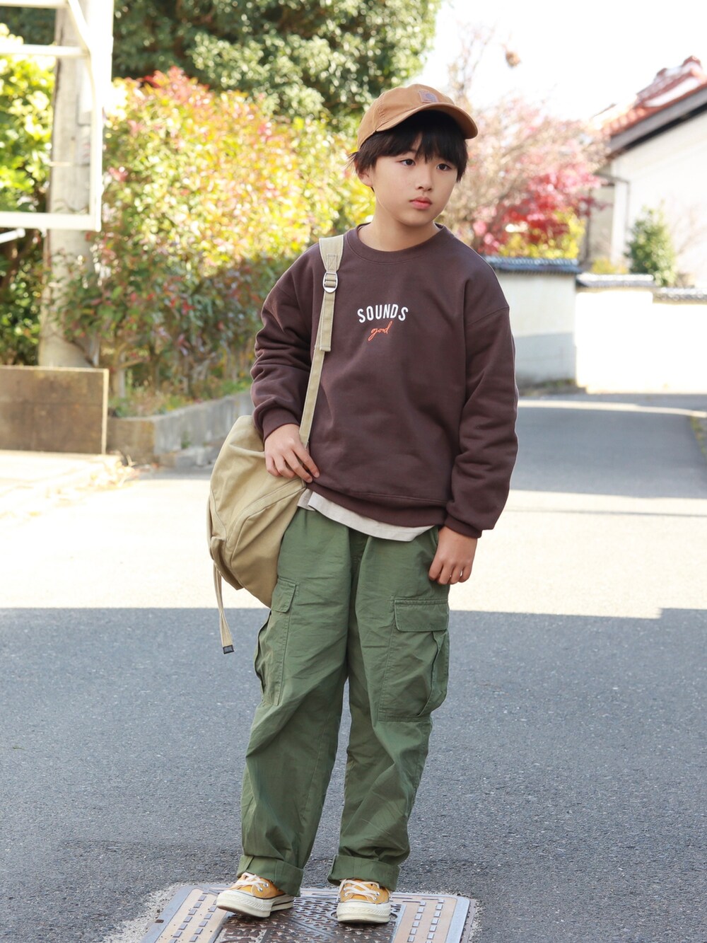 ブラウン系のスウェット、グリーン系のカーゴパンツ、イエロー系のスニーカーを着用したキッズの秋コーディネートの2枚目の写真