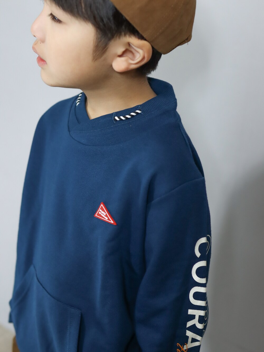 グリーン系のスウェット、ブラウン系のその他パンツ、ブラウン系のキャップを着用したキッズの秋コーディネートの3枚目の写真