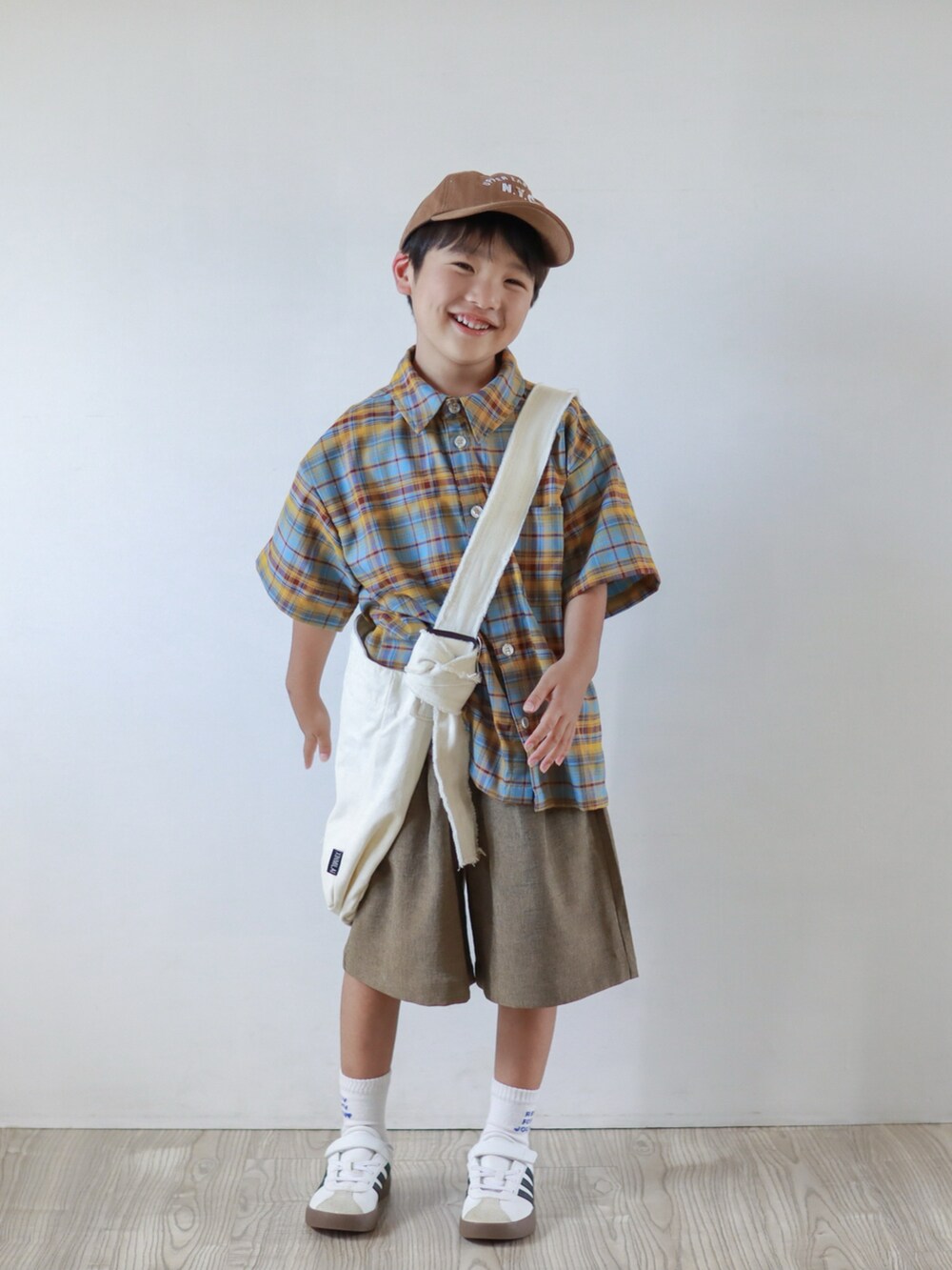 ブルー系のシャツ/ブラウス、ブラウン系のその他パンツ、ホワイト系のスニーカーを着用したキッズの夏コーディネートの2枚目の写真