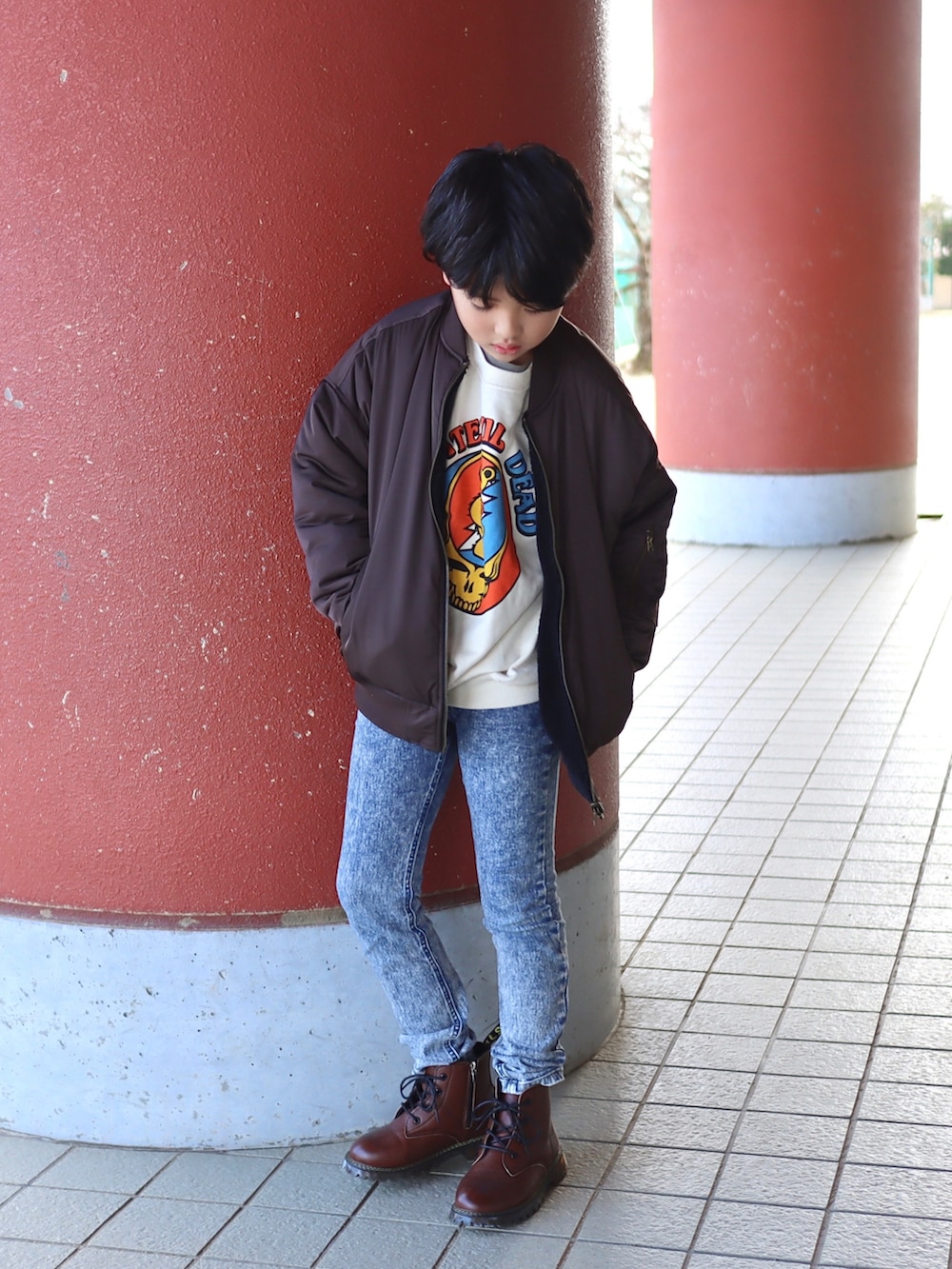 ホワイト系のスウェット、ブラウン系のMA-1、ブルー系のデニムパンツを着用したキッズの秋コーディネートの4枚目の写真