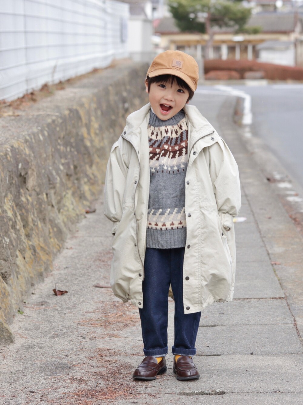 ベージュ系のモッズコート、グレー系のニット/セーター、ブルー系のデニムパンツを着用したキッズの冬コーディネートの3枚目の写真