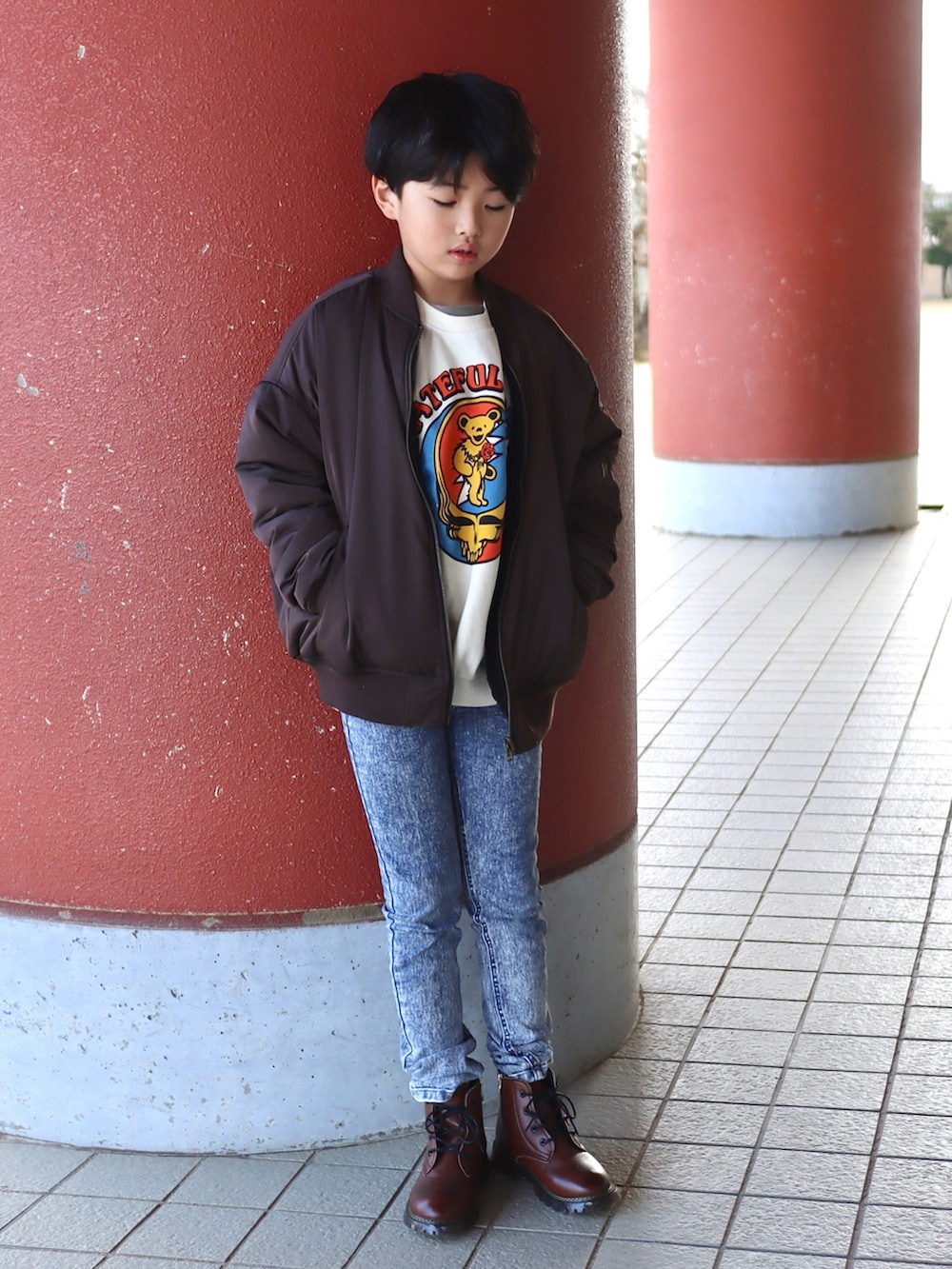 ホワイト系のスウェット、ブラウン系のMA-1、ブルー系のデニムパンツを着用したキッズの秋コーディネートの5枚目の写真