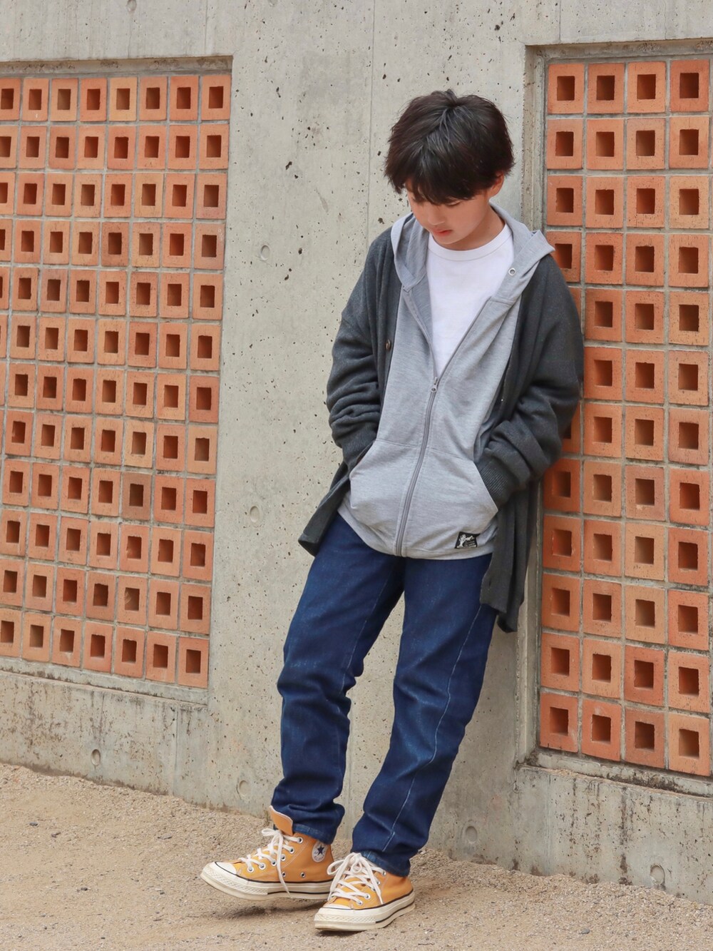 グレー系のカーディガン/ボレロ、ブルー系のデニムパンツ、イエロー系のスニーカーを着用したキッズの秋コーディネートの2枚目の写真