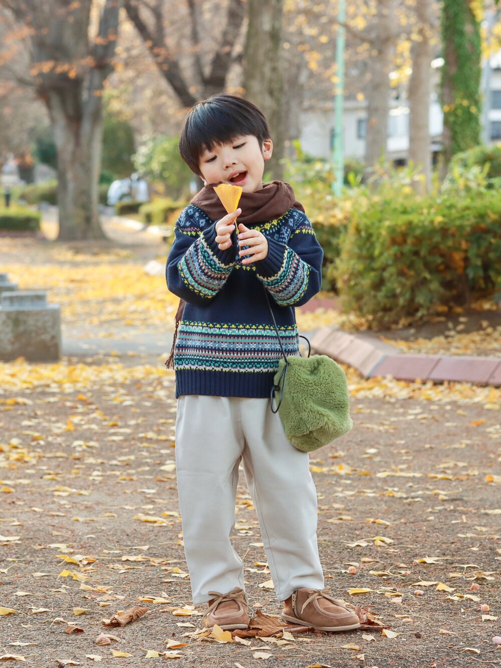 ブルー系のニット/セーター、グリーン系のショルダーバッグ、ホワイト系のその他パンツを着用したキッズの秋コーディネートの3枚目の写真