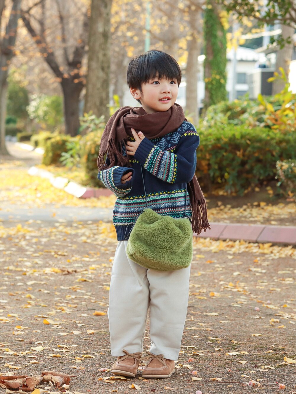 ブルー系のニット/セーター、グリーン系のショルダーバッグ、ホワイト系のその他パンツを着用したキッズの秋コーディネートの5枚目の写真