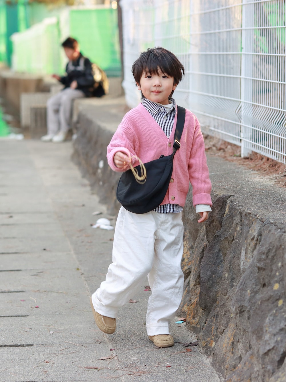 その他のカーディガン/ボレロ、ブラック系のシャツ/ブラウス、ホワイト系のパンツを着用したキッズの冬コーディネートの2枚目の写真