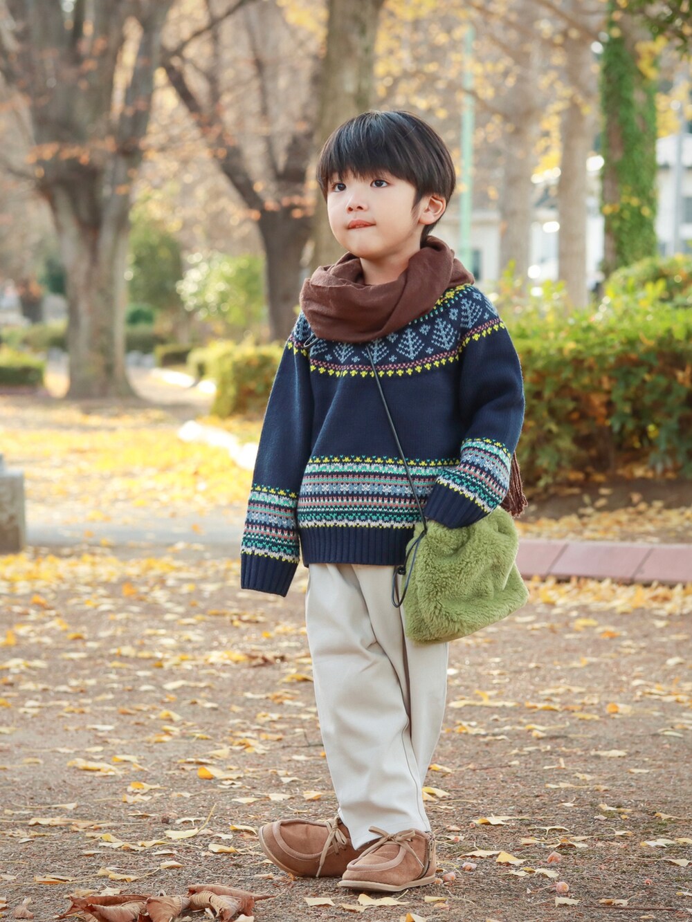 ブルー系のニット/セーター、グリーン系のショルダーバッグ、ホワイト系のその他パンツを着用したキッズの秋コーディネートの2枚目の写真