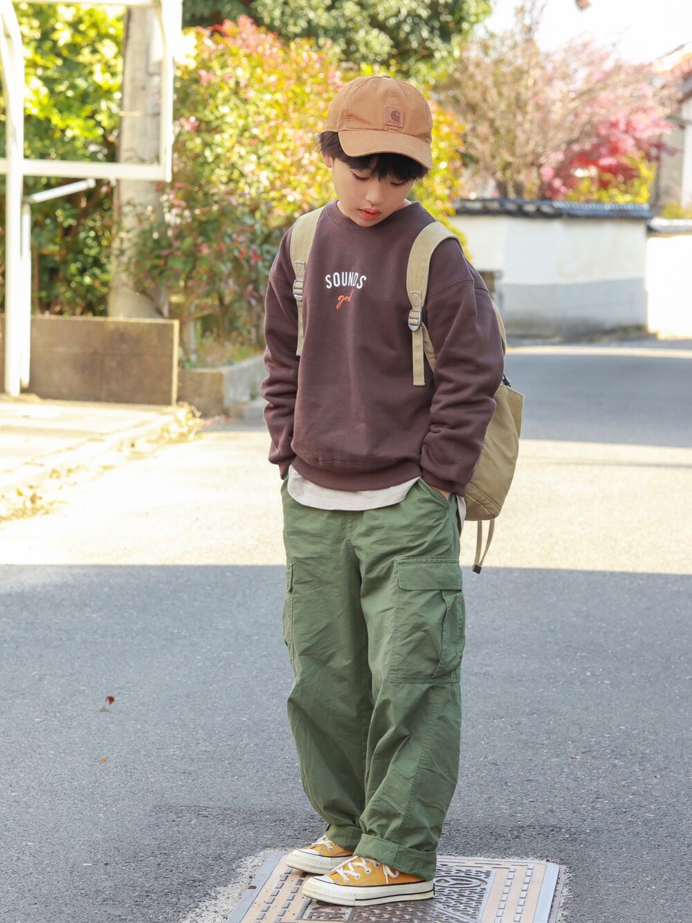 ブラウン系のスウェット、グリーン系のカーゴパンツ、イエロー系のスニーカーを着用したキッズの秋コーディネートの3枚目の写真