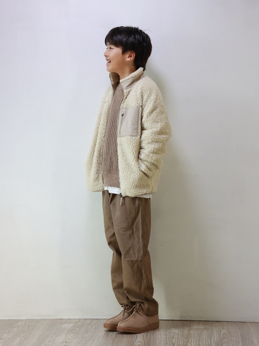 ベージュ系のジャケット/アウター、ベージュ系のニット/セーター、ブラウン系のその他パンツを着用したキッズの冬コーディネートの3枚目の写真