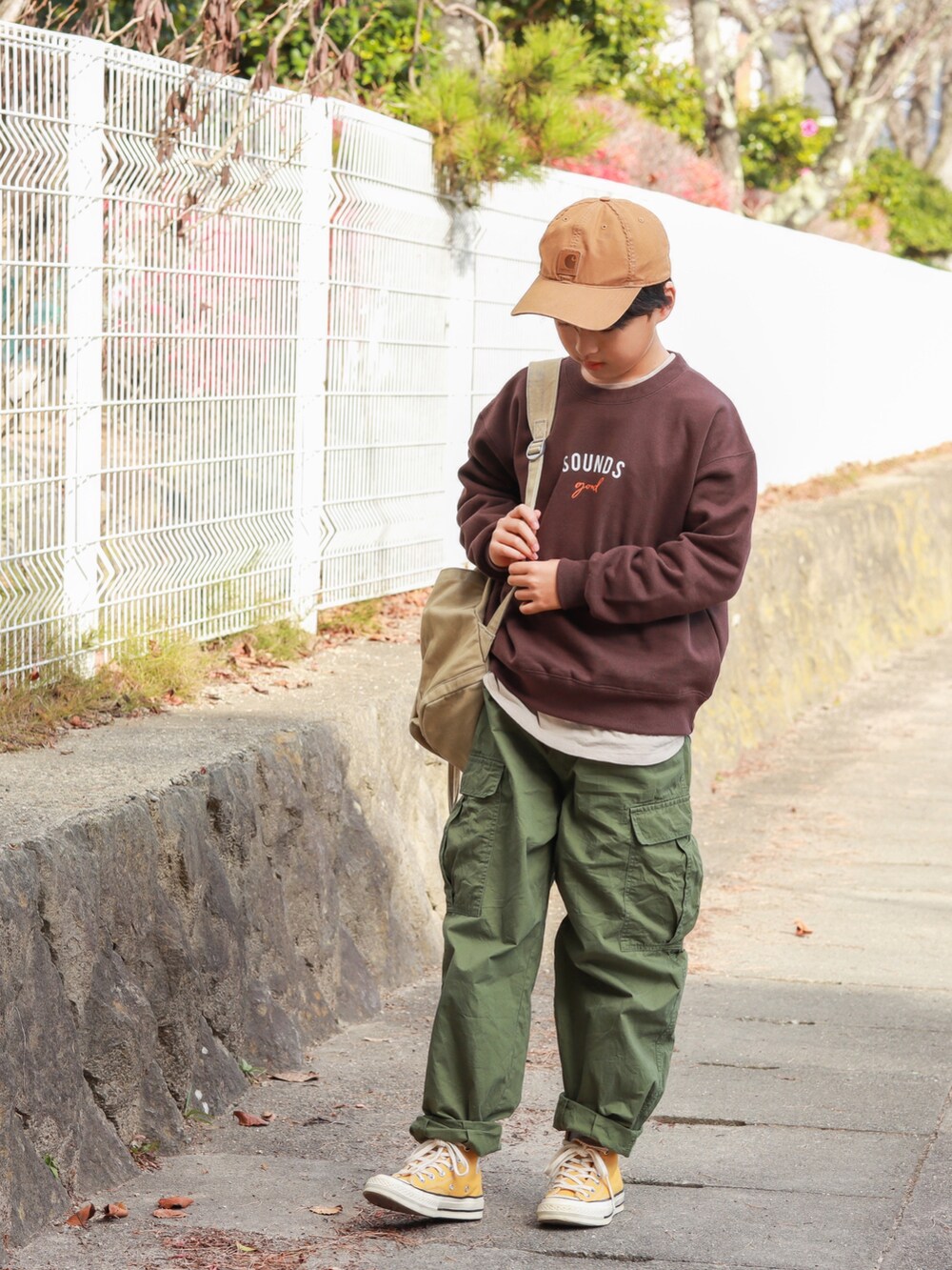 ブラウン系のスウェット、グリーン系のカーゴパンツ、イエロー系のスニーカーを着用したキッズの秋コーディネートの5枚目の写真