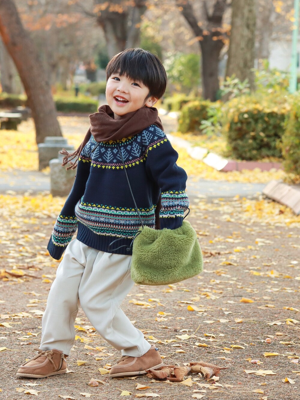 ブルー系のニット/セーター、グリーン系のショルダーバッグ、ホワイト系のその他パンツを着用したキッズの秋コーディネートの4枚目の写真