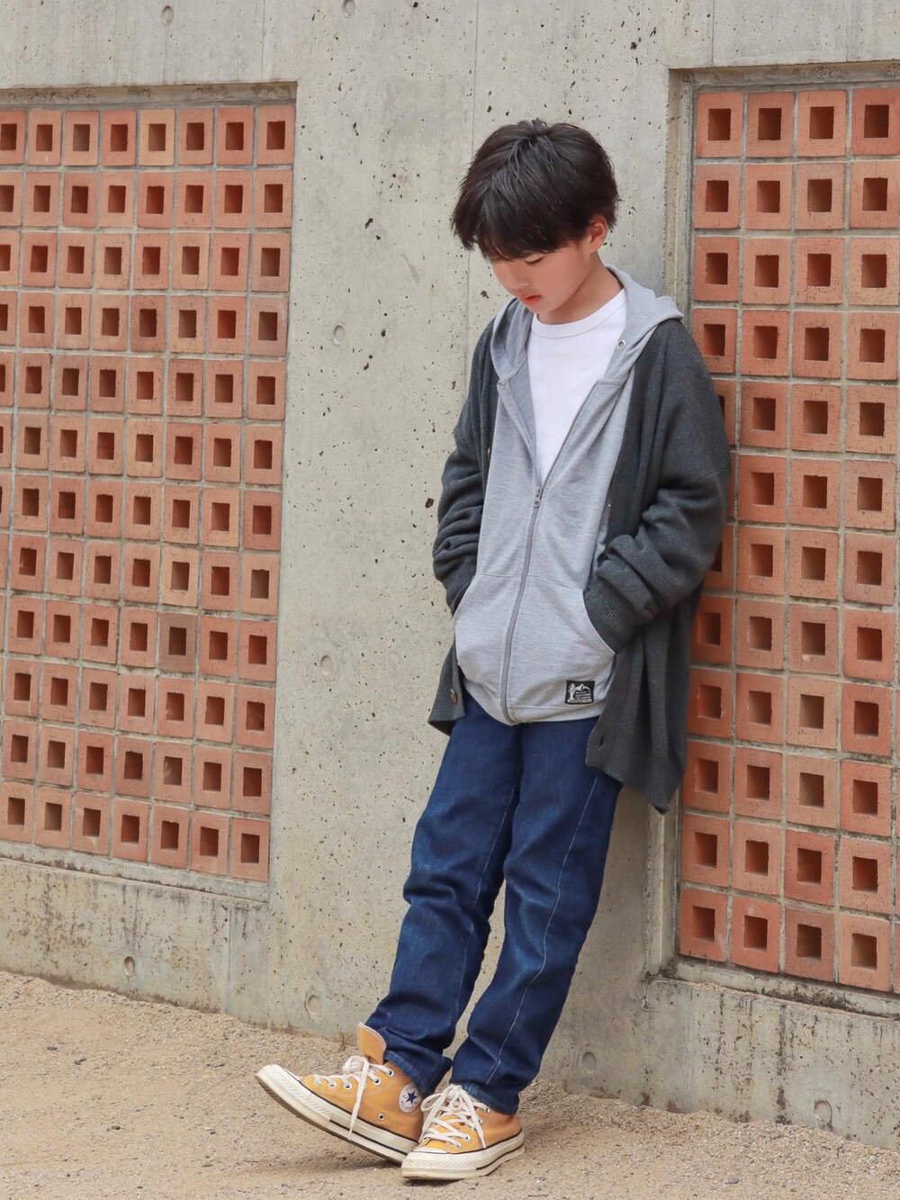グレー系のカーディガン/ボレロ、ブルー系のデニムパンツ、イエロー系のスニーカーを着用したキッズの秋コーディネートの3枚目の写真