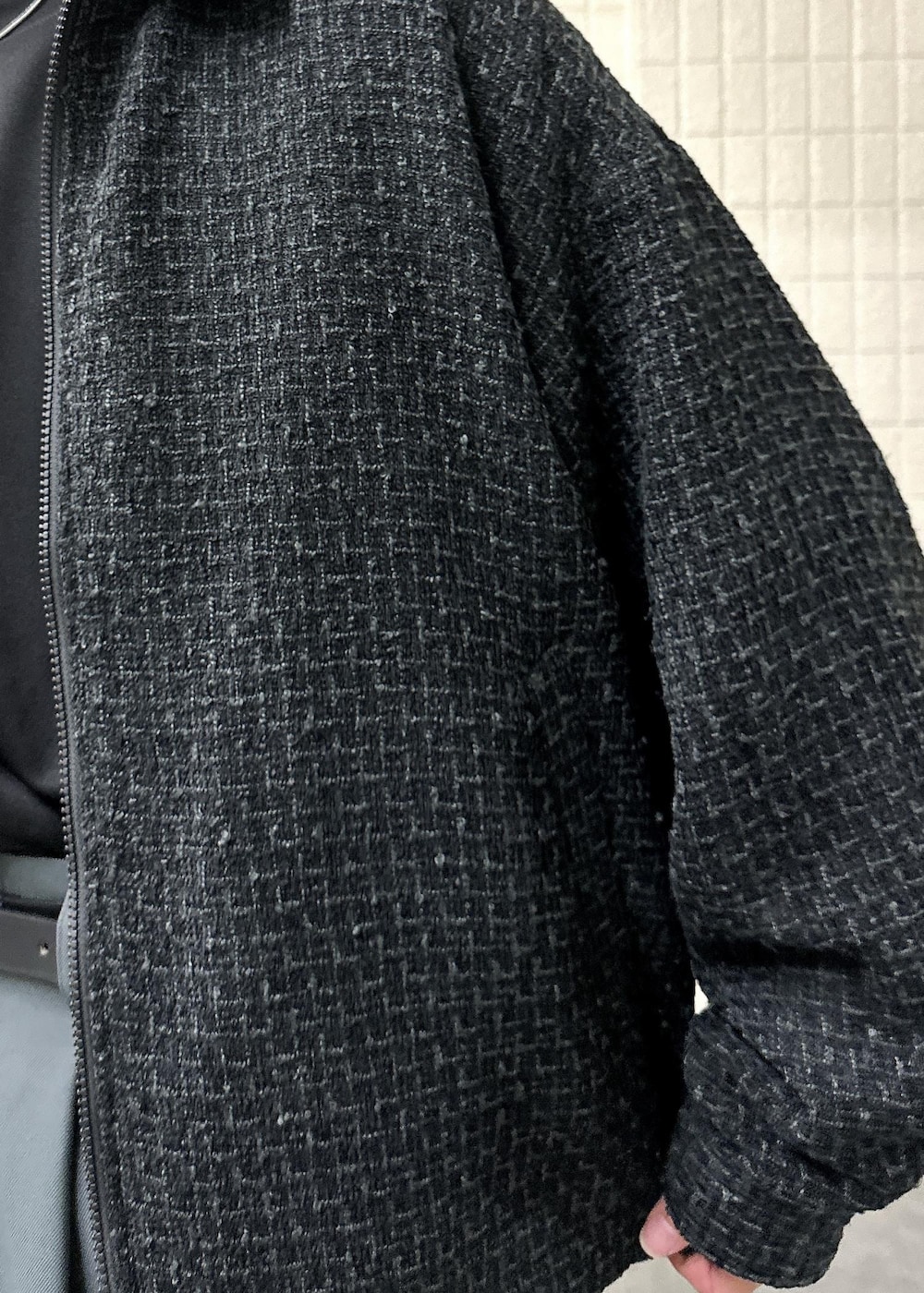 ブラック系のブルゾン、ブラック系のTシャツ/カットソー、グレー系のスラックスを着用したメンズの秋コーディネートの6枚目の写真