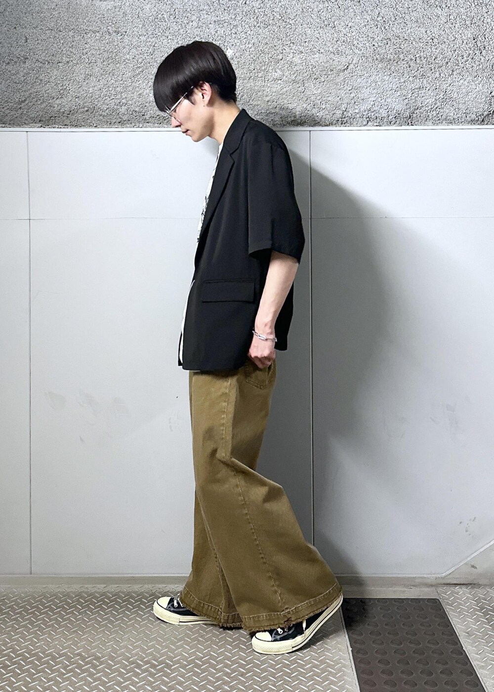 グレー系のTシャツ/カットソー、ベージュ系のデニムパンツ、ブラック系のテーラードジャケットを着用したメンズの春コーディネートの2枚目の写真