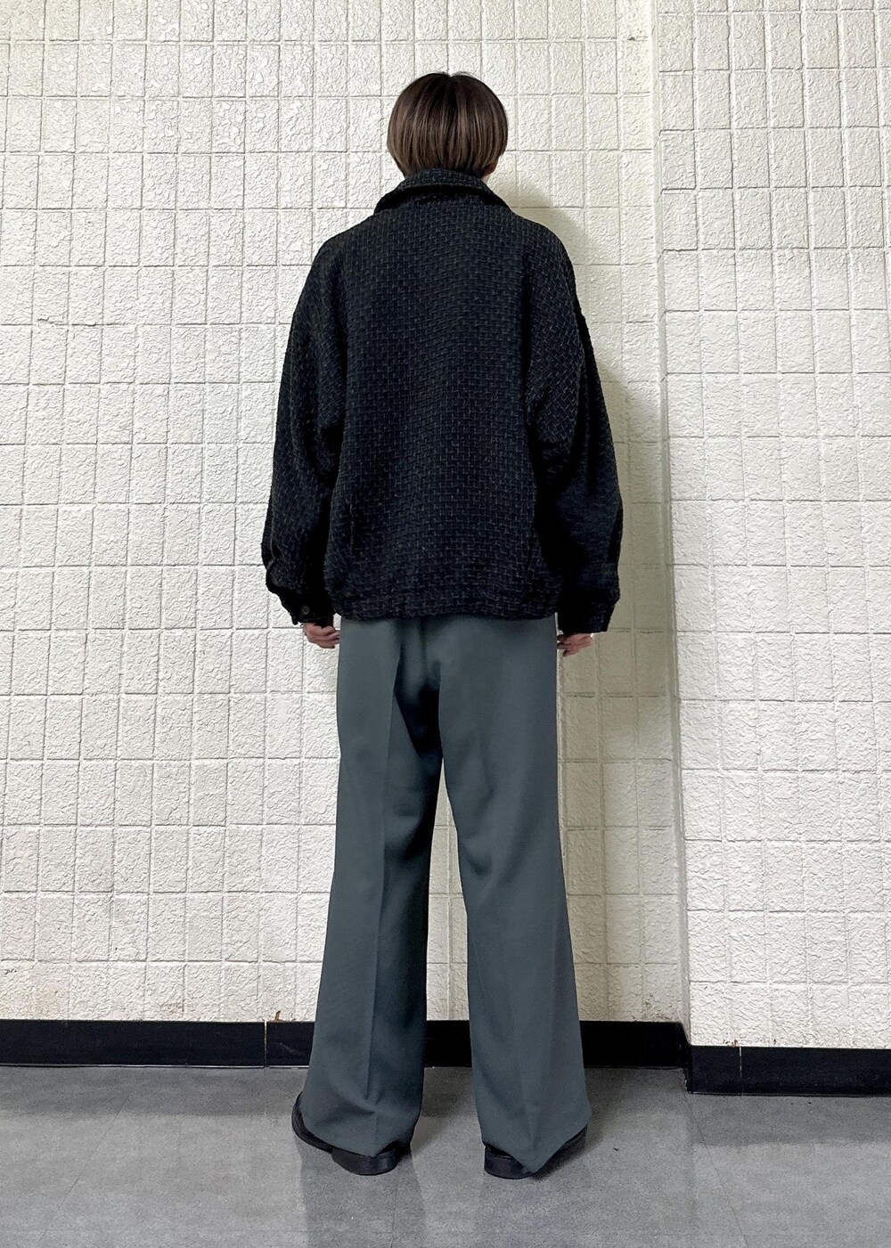 ブラック系のブルゾン、ブラック系のTシャツ/カットソー、グレー系のスラックスを着用したメンズの秋コーディネートの3枚目の写真