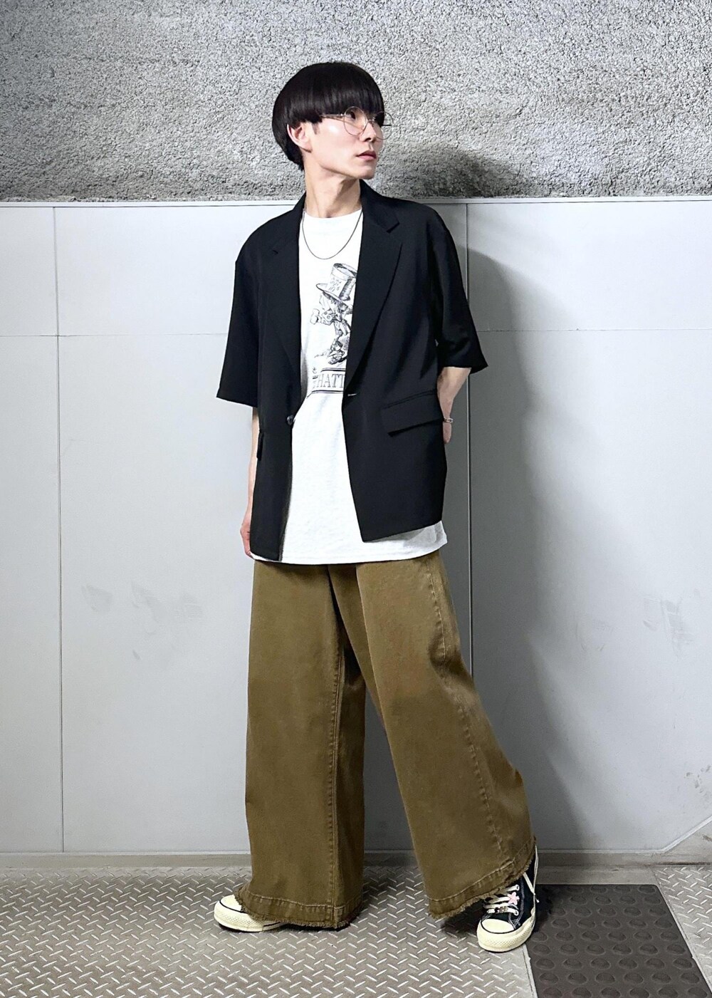 グレー系のTシャツ/カットソー、ベージュ系のデニムパンツ、ブラック系のテーラードジャケットを着用したメンズの春コーディネートの9枚目の写真