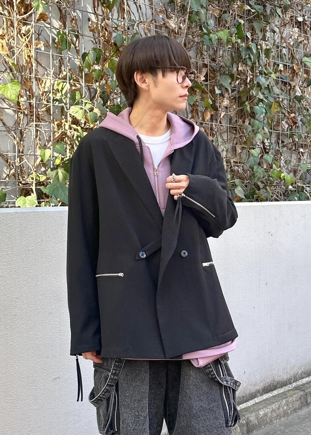 パープル系のパーカー、グレー系のカーゴパンツ、ブラック系のテーラードジャケットを着用したメンズの冬コーディネートの6枚目の写真