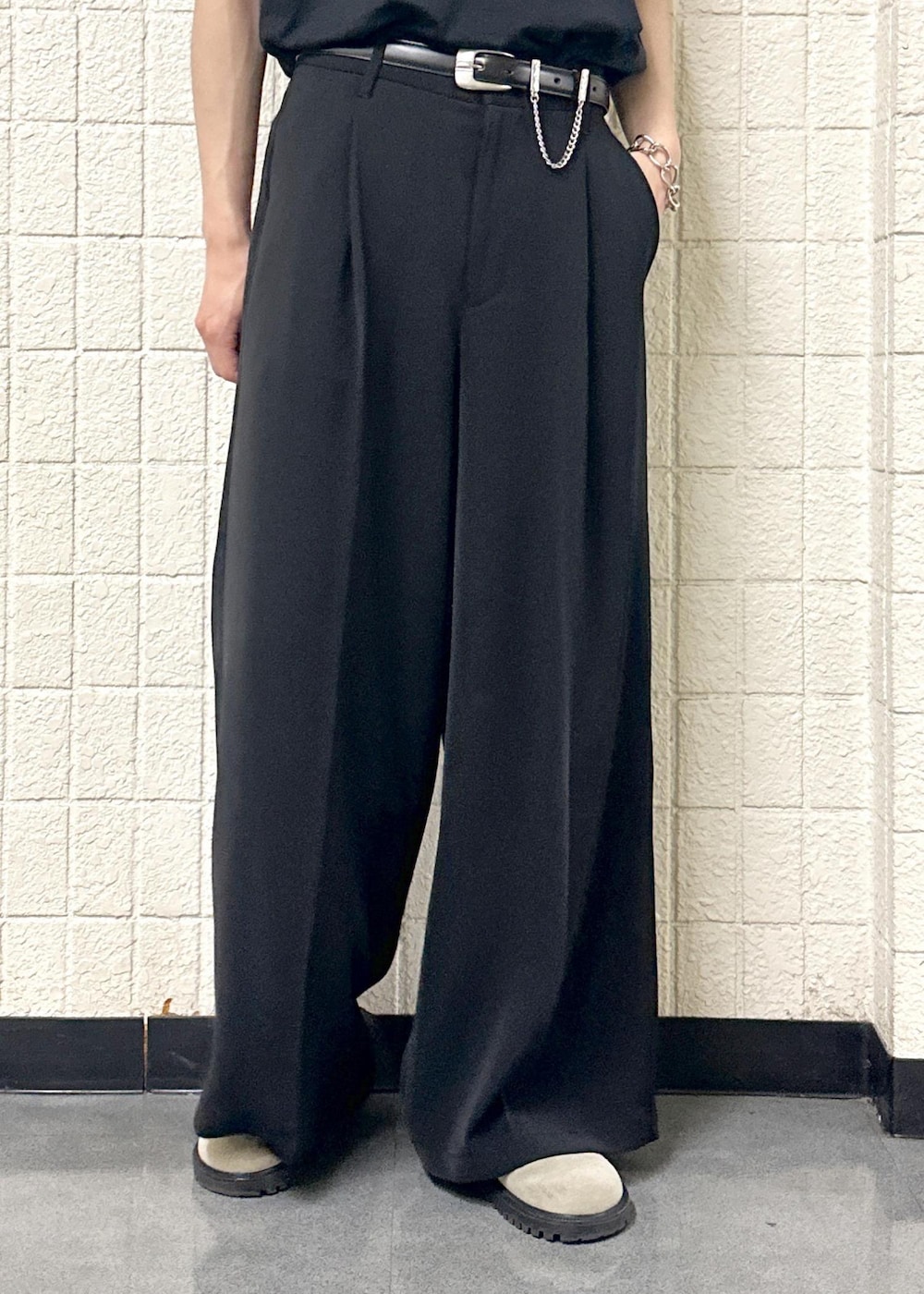 グレー系のTシャツ/カットソー、ブラック系のスラックス、シルバー系のリングを着用したメンズの春コーディネートの10枚目の写真