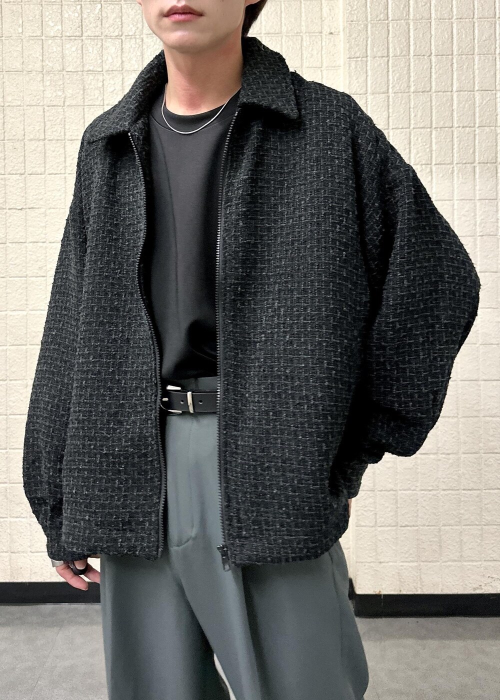 ブラック系のブルゾン、ブラック系のTシャツ/カットソー、グレー系のスラックスを着用したメンズの秋コーディネートの5枚目の写真