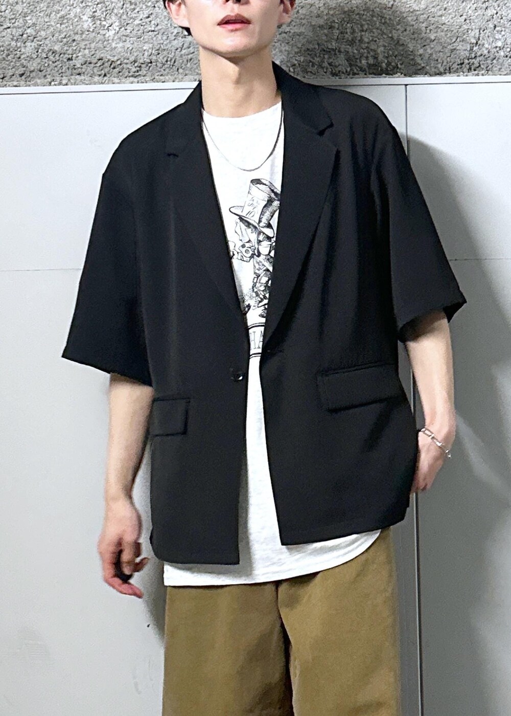 グレー系のTシャツ/カットソー、ベージュ系のデニムパンツ、ブラック系のテーラードジャケットを着用したメンズの春コーディネートの5枚目の写真