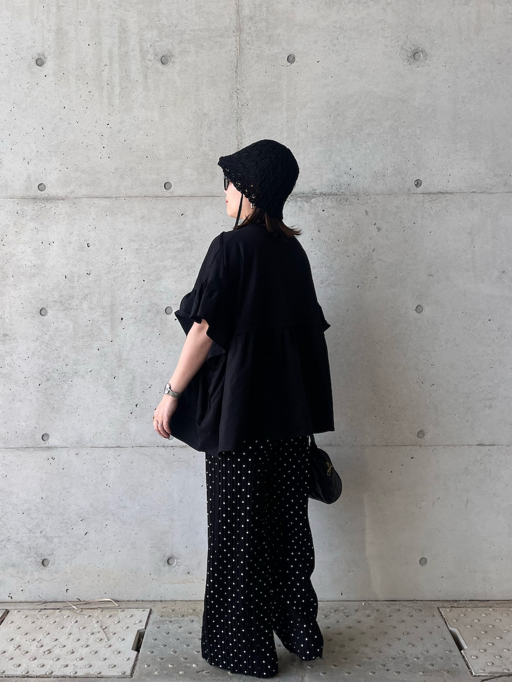 ブラック系のTシャツ/カットソー、ブラック系のその他パンツ、シルバー系のパンプスを着用したレディースの春コーディネートの4枚目の写真