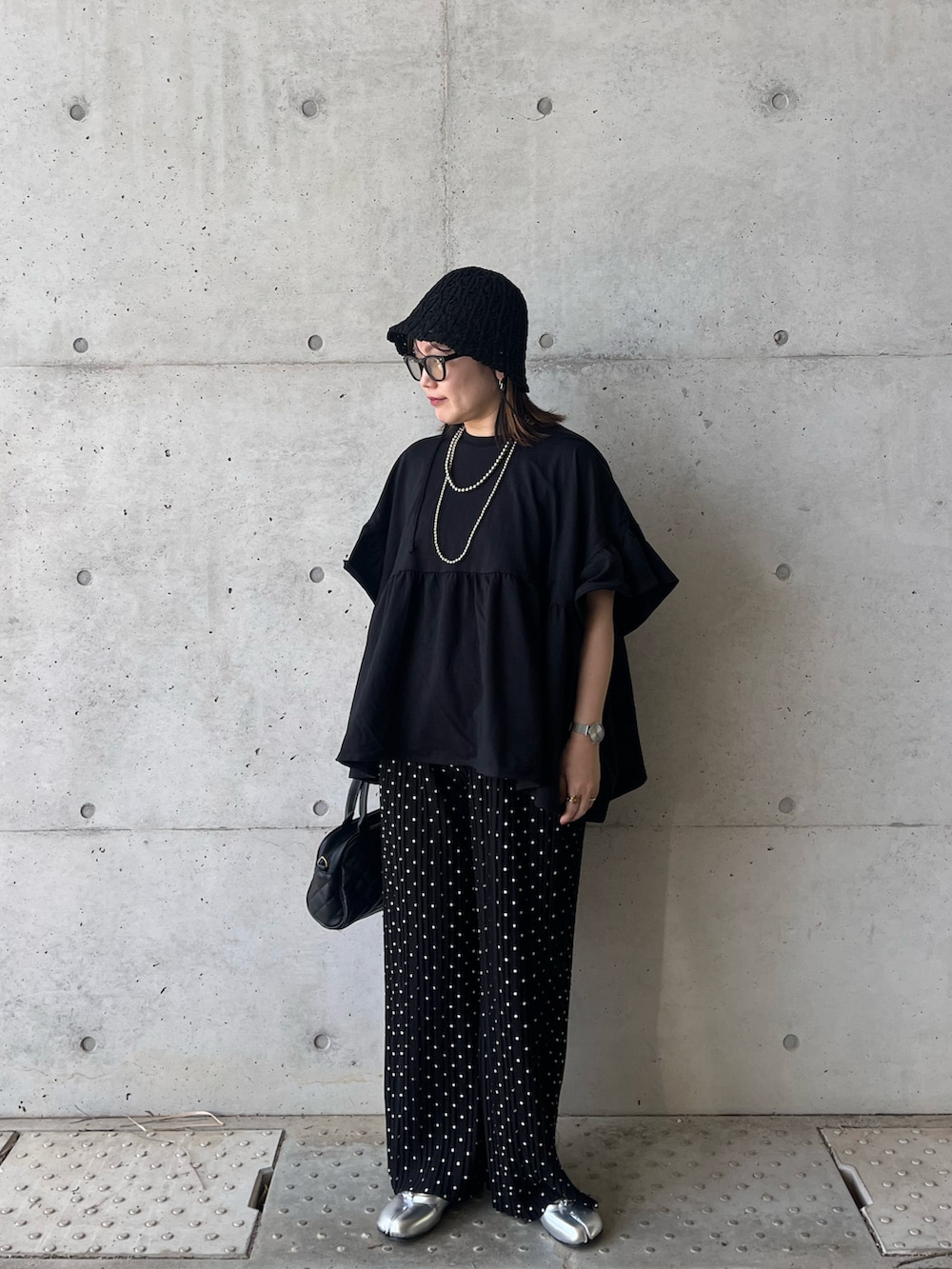 ブラック系のTシャツ/カットソー、ブラック系のその他パンツ、シルバー系のパンプスを着用したレディースの春コーディネートの3枚目の写真
