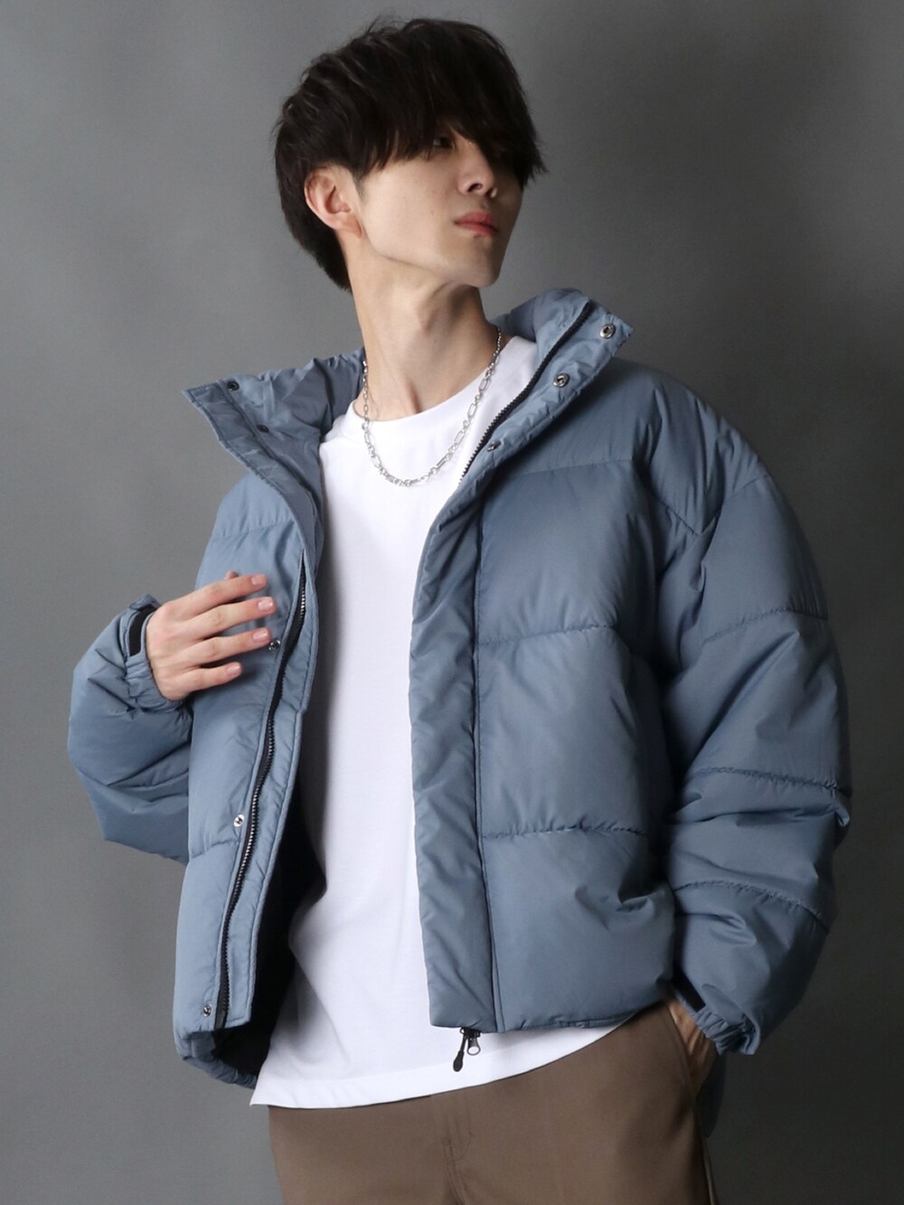 グレー系のダウンジャケット/コート、ブラウン系のチノパンツ、ブラック系のスニーカーを着用したメンズの秋コーディネートの4枚目の写真