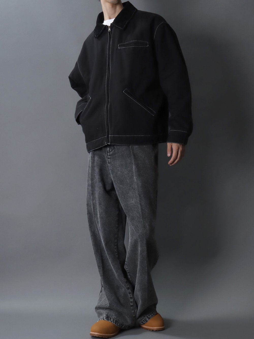 ブラック系のブルゾン、ブラック系のデニムパンツ、ブラック系のベルトを着用したメンズの冬コーディネートの2枚目の写真