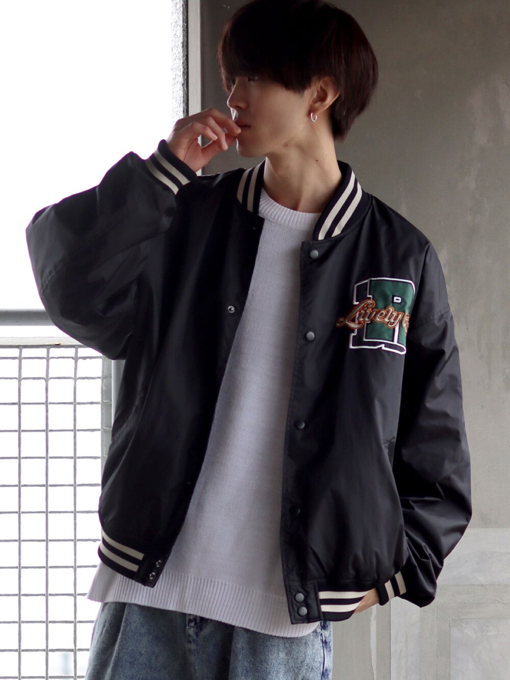 ブラック系のスタジャン、ホワイト系のTシャツ/カットソー、ブルー系のデニムパンツを着用したメンズの秋コーディネートの2枚目の写真