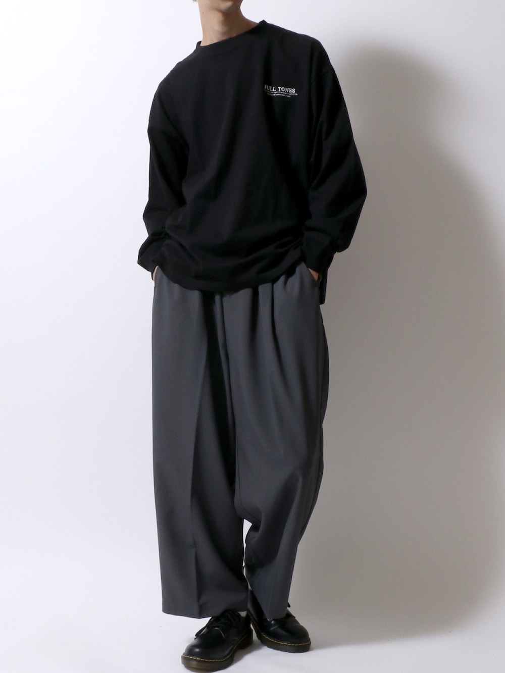 ブラック系のTシャツ/カットソー、ホワイト系のタンクトップ、グレー系のスラックスを着用したメンズの秋コーディネートの2枚目の写真