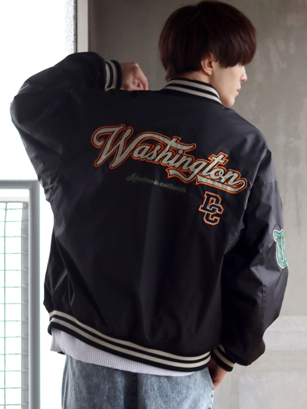 ブラック系のスタジャン、ホワイト系のTシャツ/カットソー、ブルー系のデニムパンツを着用したメンズの秋コーディネートの3枚目の写真