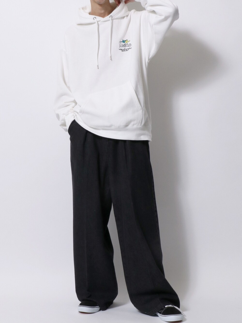 ホワイト系のパーカー、ブラック系のデニムパンツ、ブラック系のスニーカーを着用したメンズの秋コーディネートの2枚目の写真