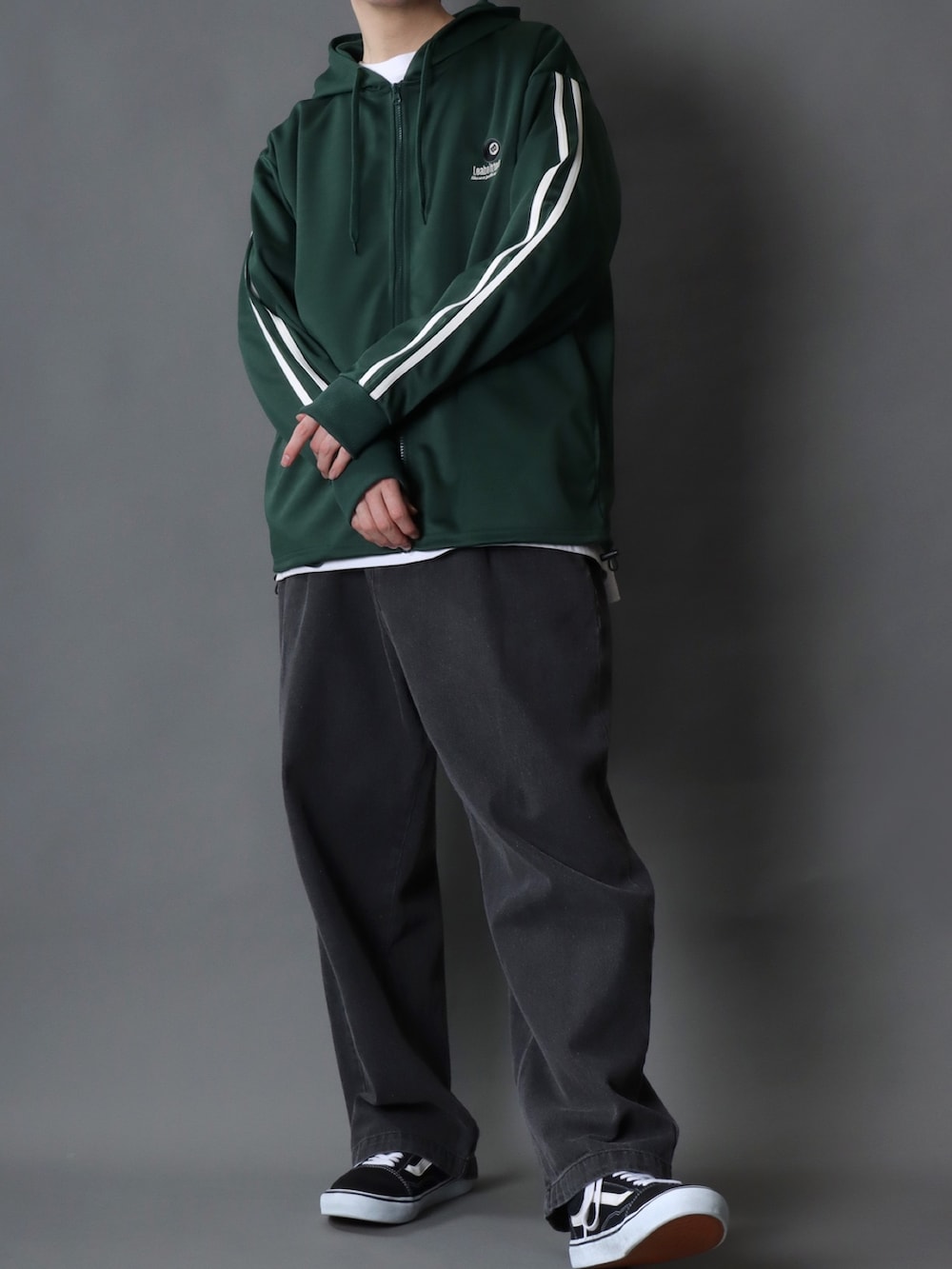 グリーン系のパーカー、ホワイト系のTシャツ/カットソー、ブラック系のデニムパンツを着用したメンズの春コーディネートの2枚目の写真