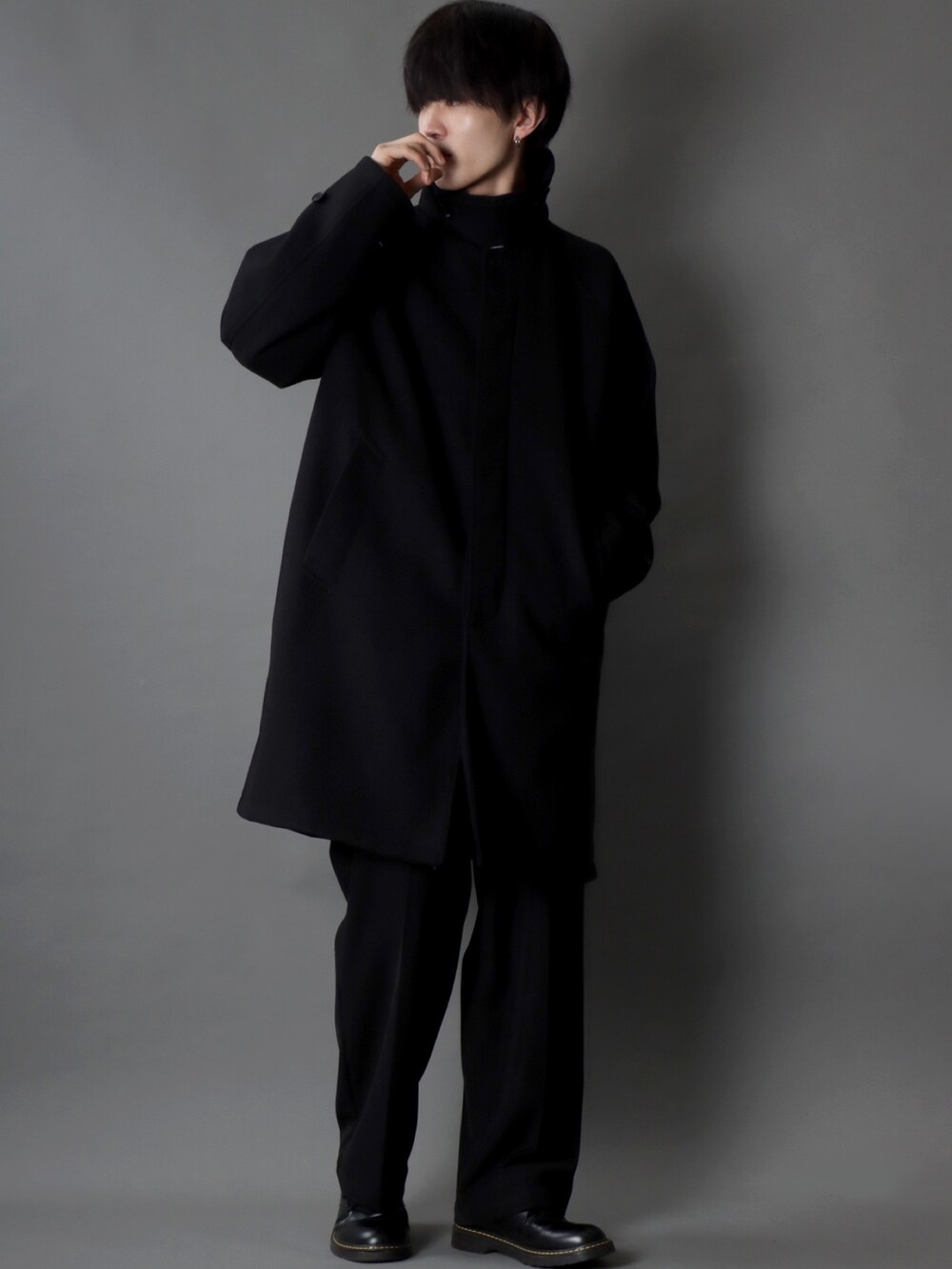 ブラック系のステンカラーコート、ホワイト系のシャツ/ブラウス、ブラック系のスラックスを着用したメンズの冬コーディネートの2枚目の写真