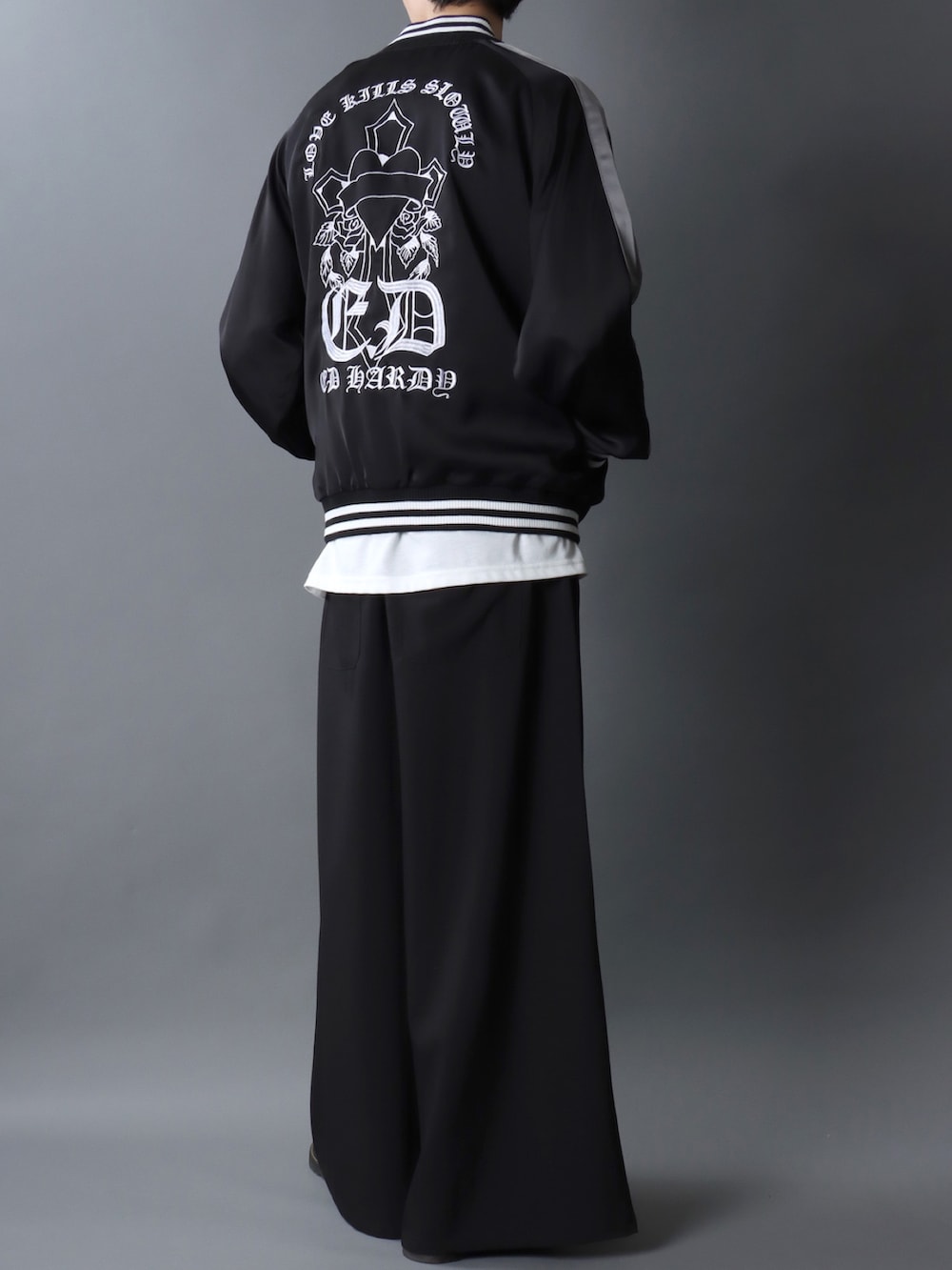 ブラック系のスカジャン、ブラック系のスラックス、ブラック系のドレスシューズを着用したメンズの冬コーディネートの2枚目の写真