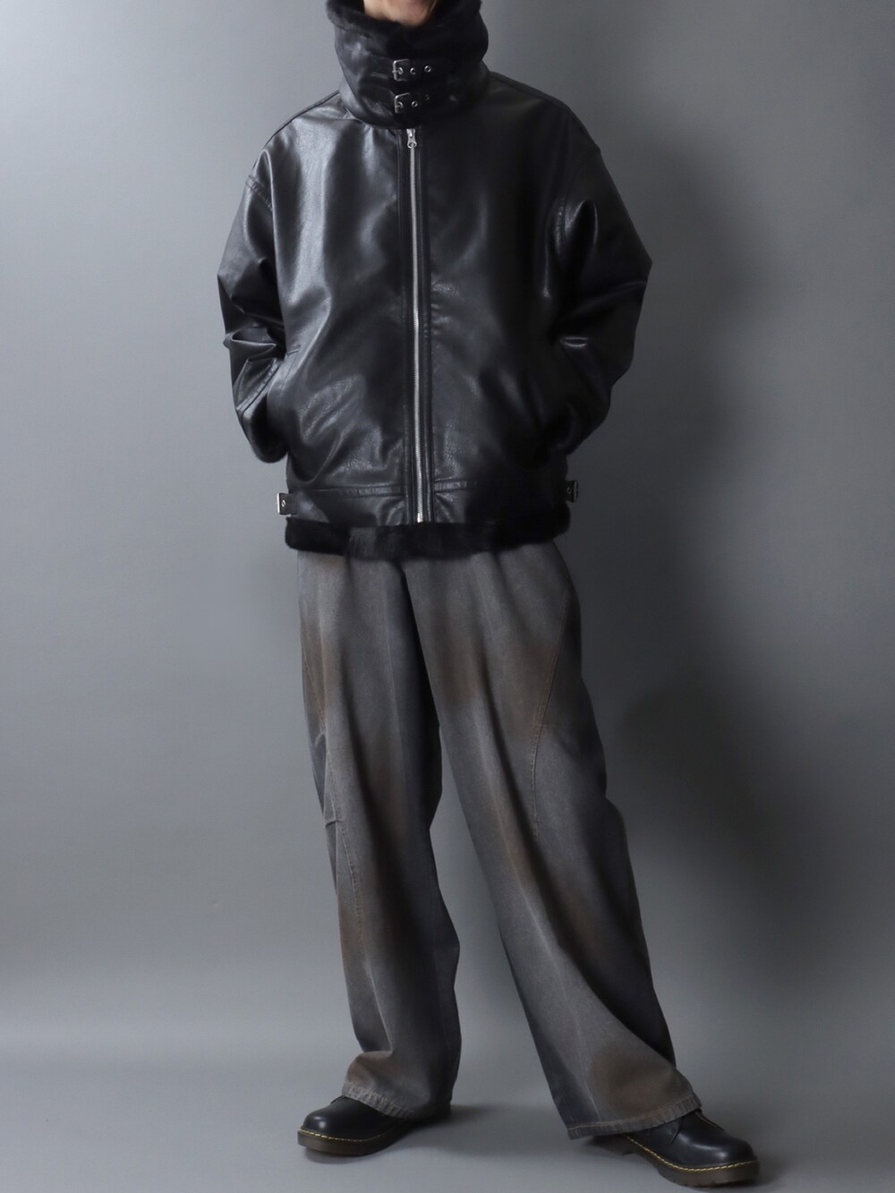 ブラック系のムートンコート、ブラック系のデニムパンツ、ブラック系のドレスシューズを着用したメンズの冬コーディネートの2枚目の写真