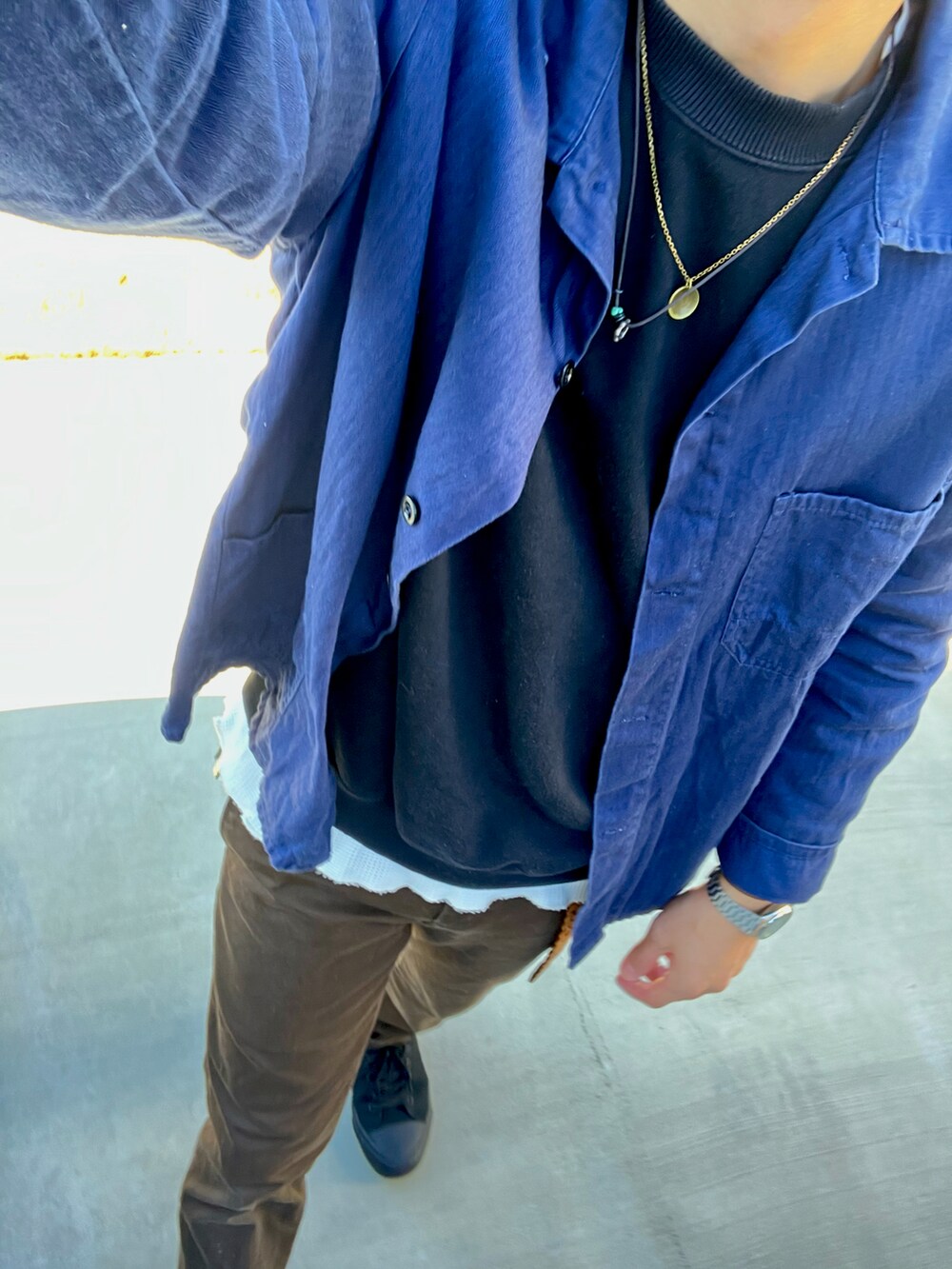 ブルー系のカバーオール、ブラック系のパーカー、ブラック系のシューズを着用したメンズの冬コーディネートの2枚目の写真